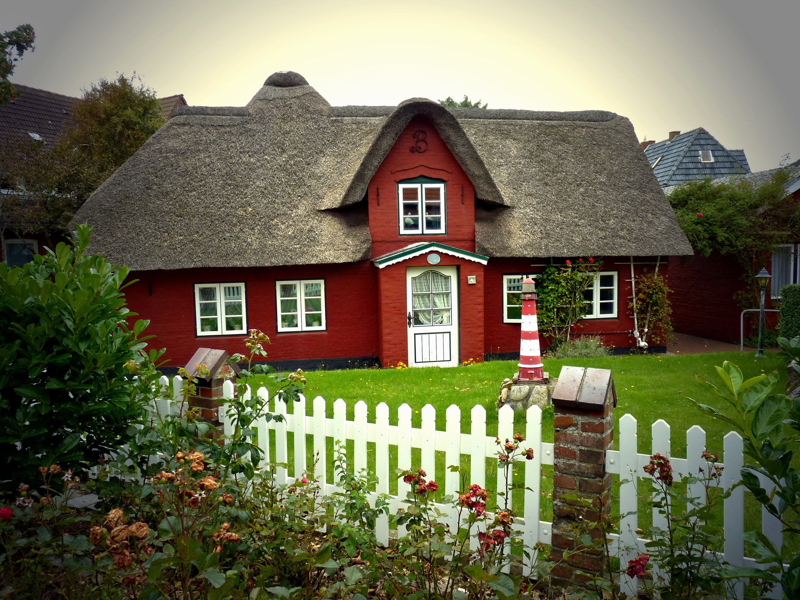 Red thatched-roof house with lighthouse decoration in Germany HD Wallpaper