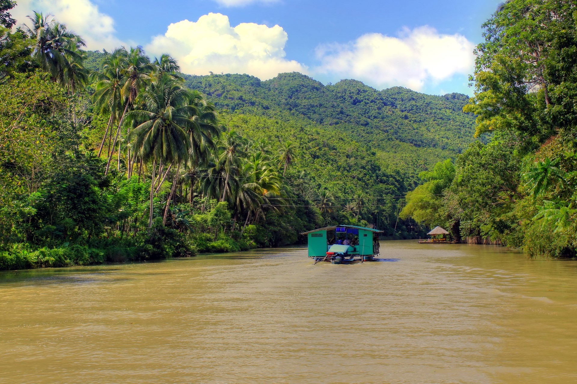 River cruise through a tropical jungle with mountains HD Wallpaper