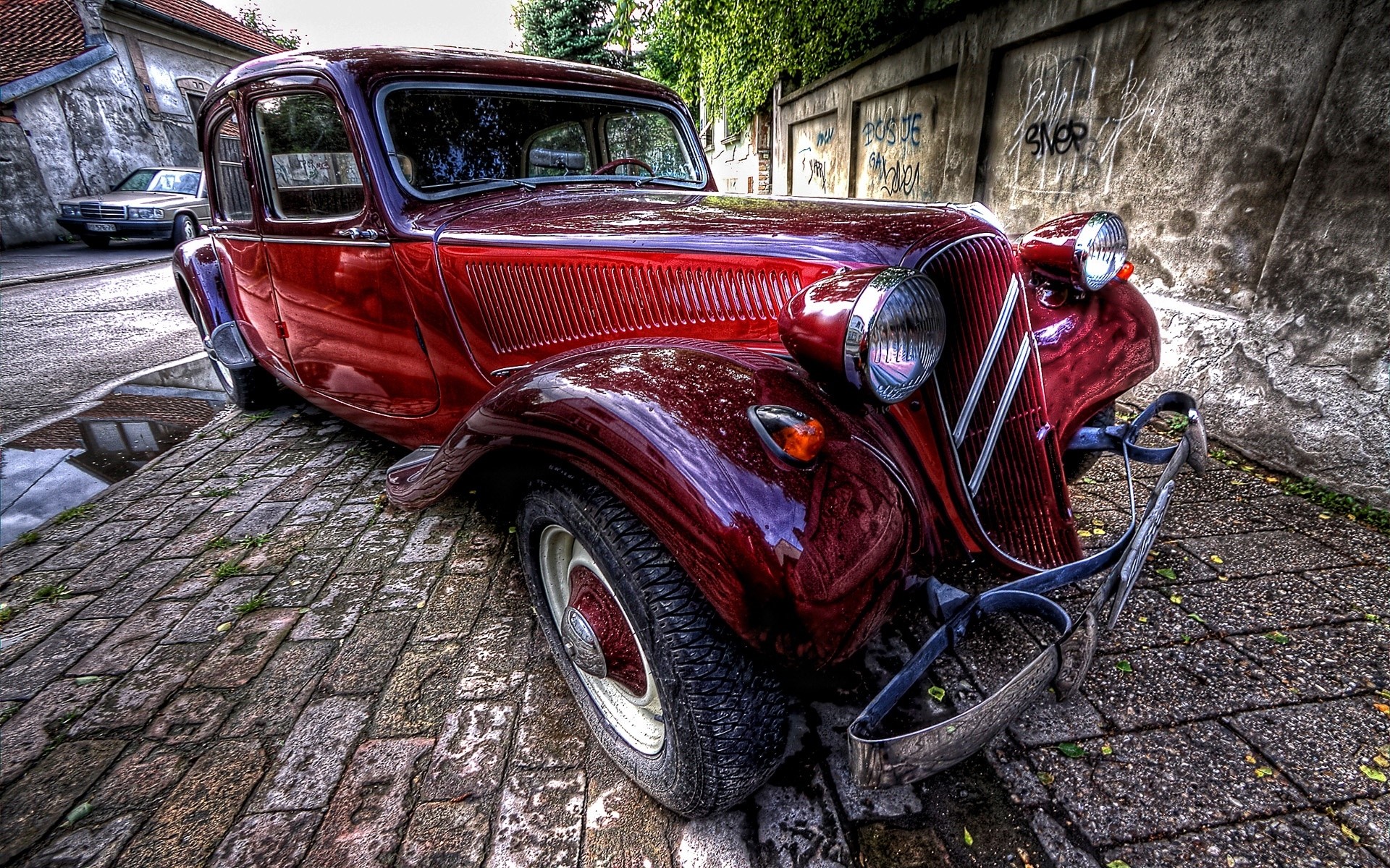 Red vintage Citroën Traction Avant car on cobblestone street HD Wallpaper