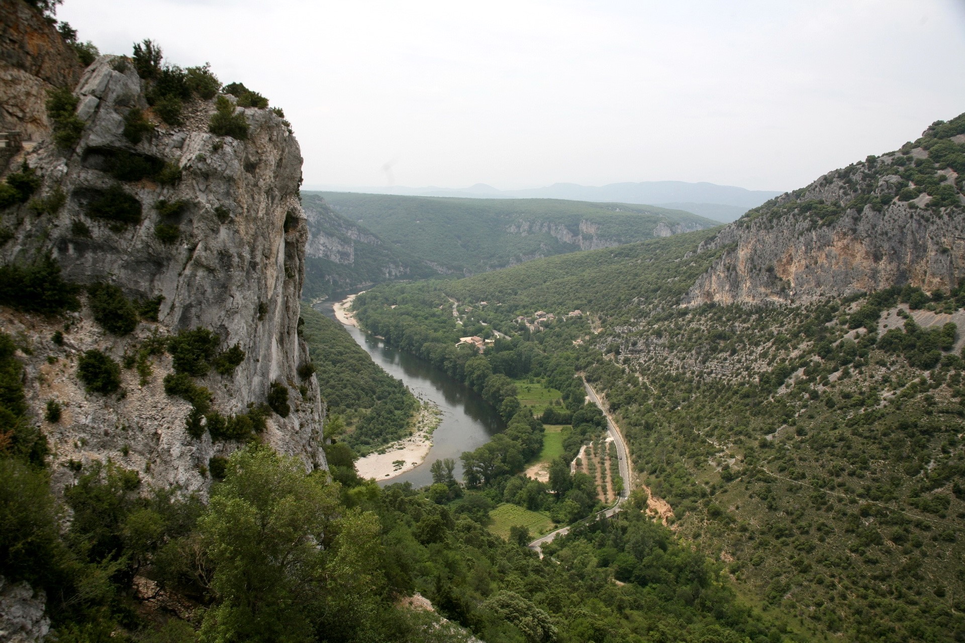River flowing through a forested canyon with rocky cliffs HD Wallpaper