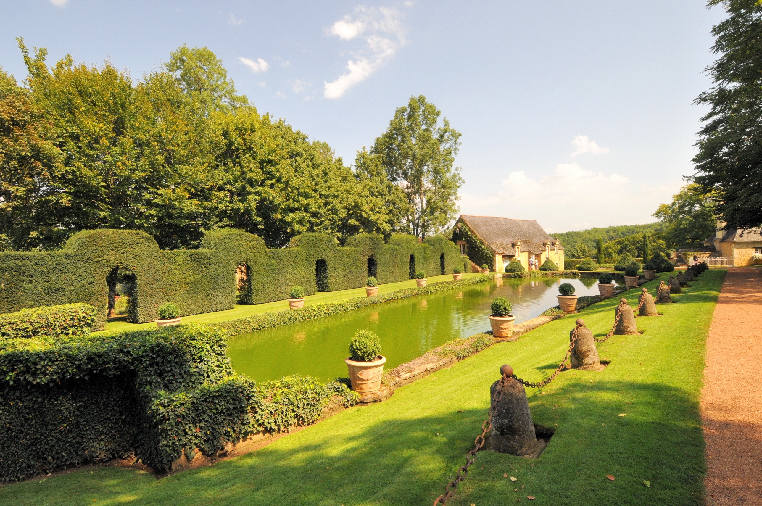 Formal gardens with a pond and a building HD Wallpaper