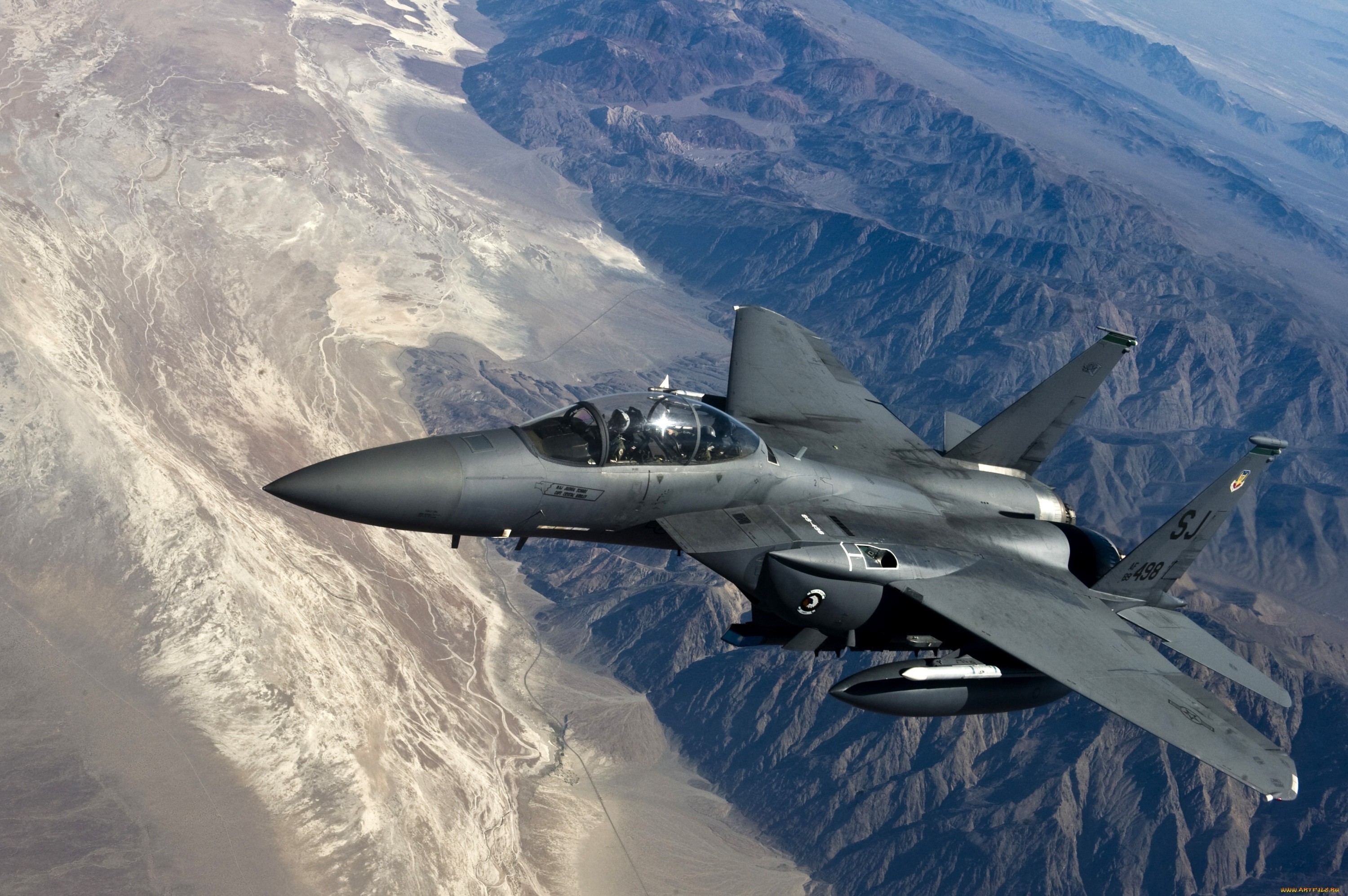 F-15 Eagle fighter jet flying over desert mountains HD Wallpaper