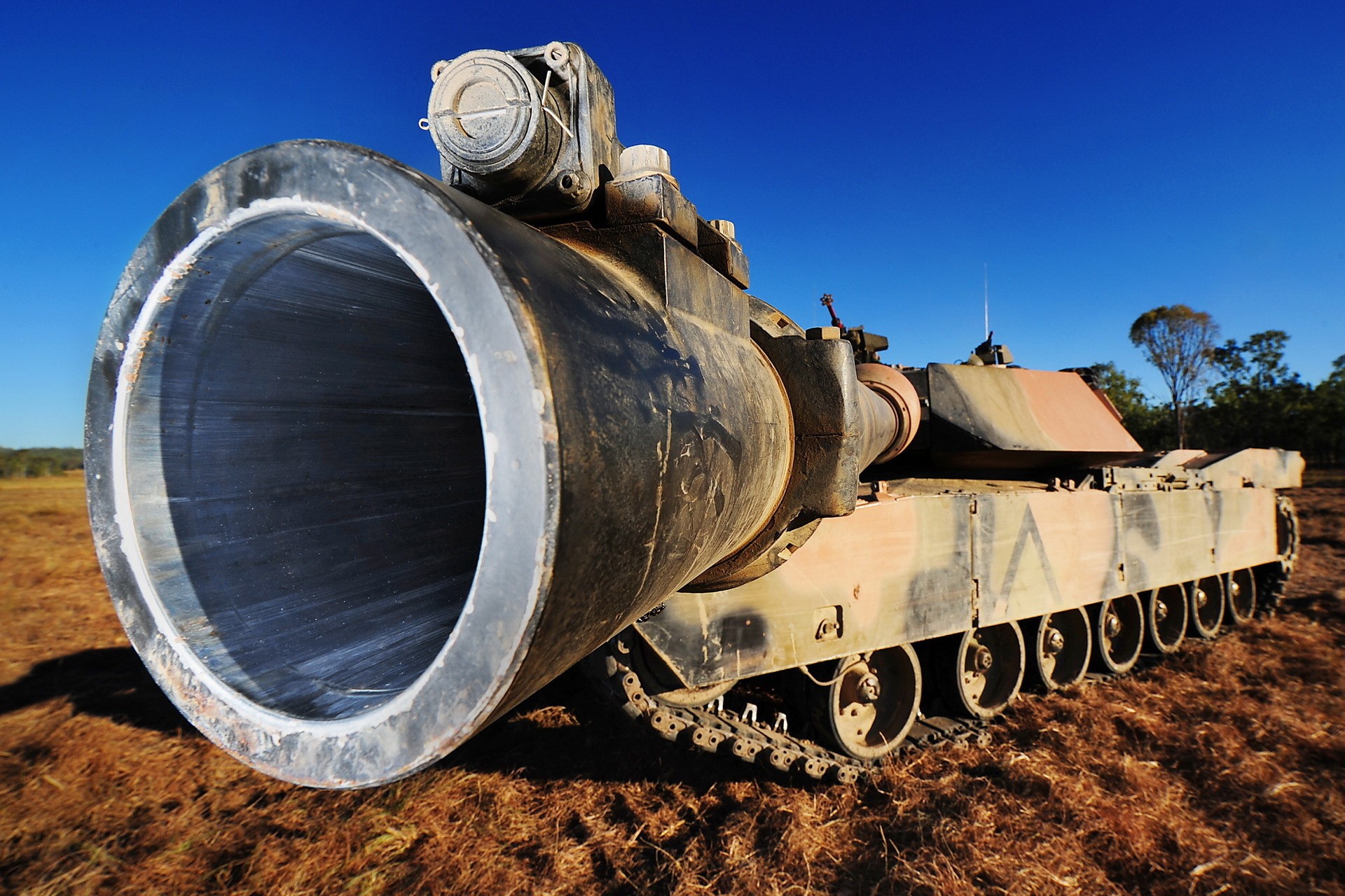 Close-up of a large tank cannon in a field HD Wallpaper