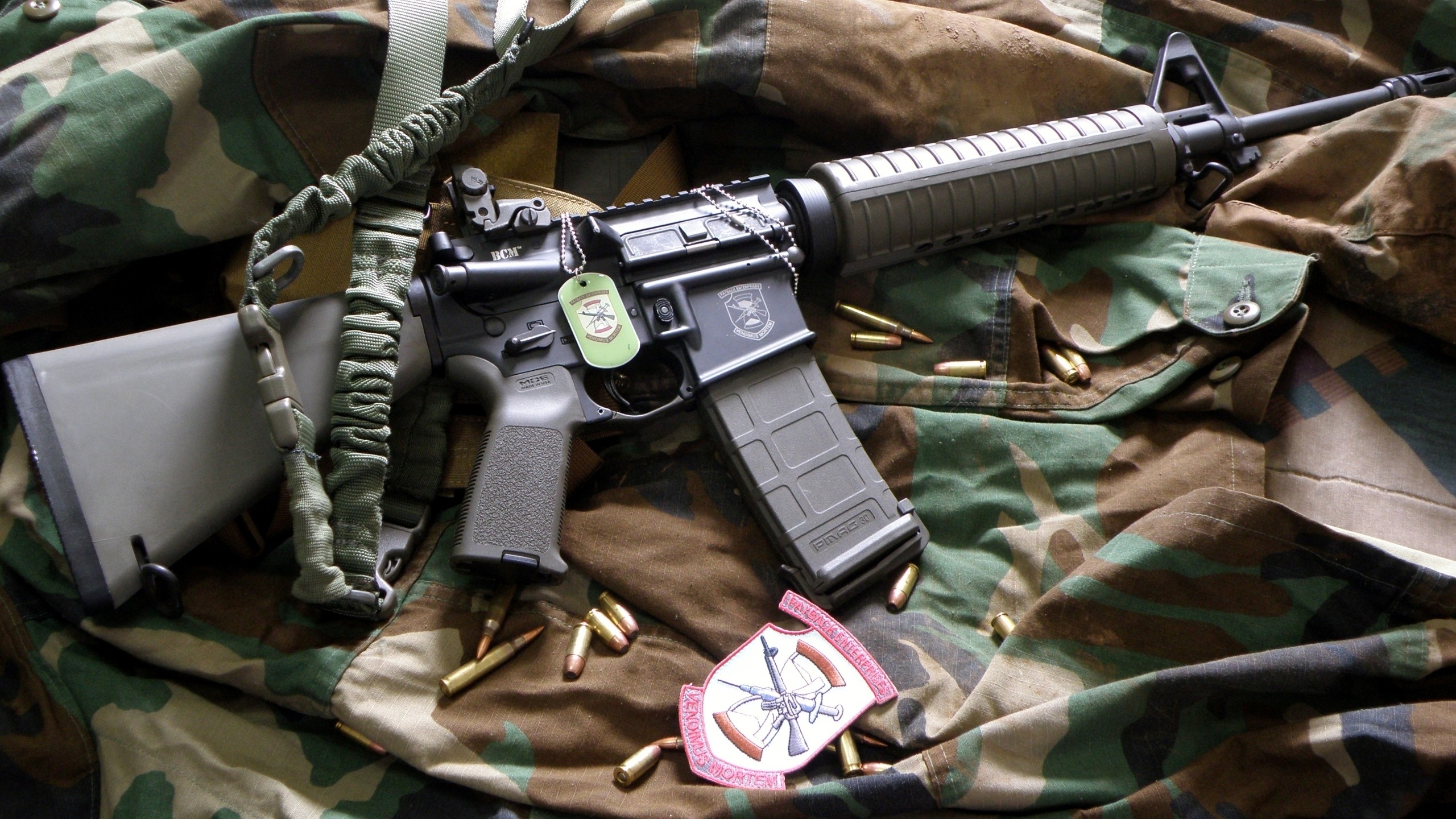 Assault rifle with ammunition and patches on camouflage fabric HD Wallpaper