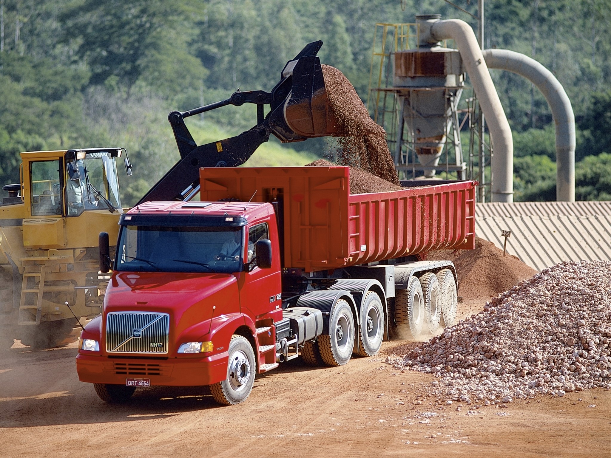 Volvo truck being loaded by excavator HD Wallpaper
