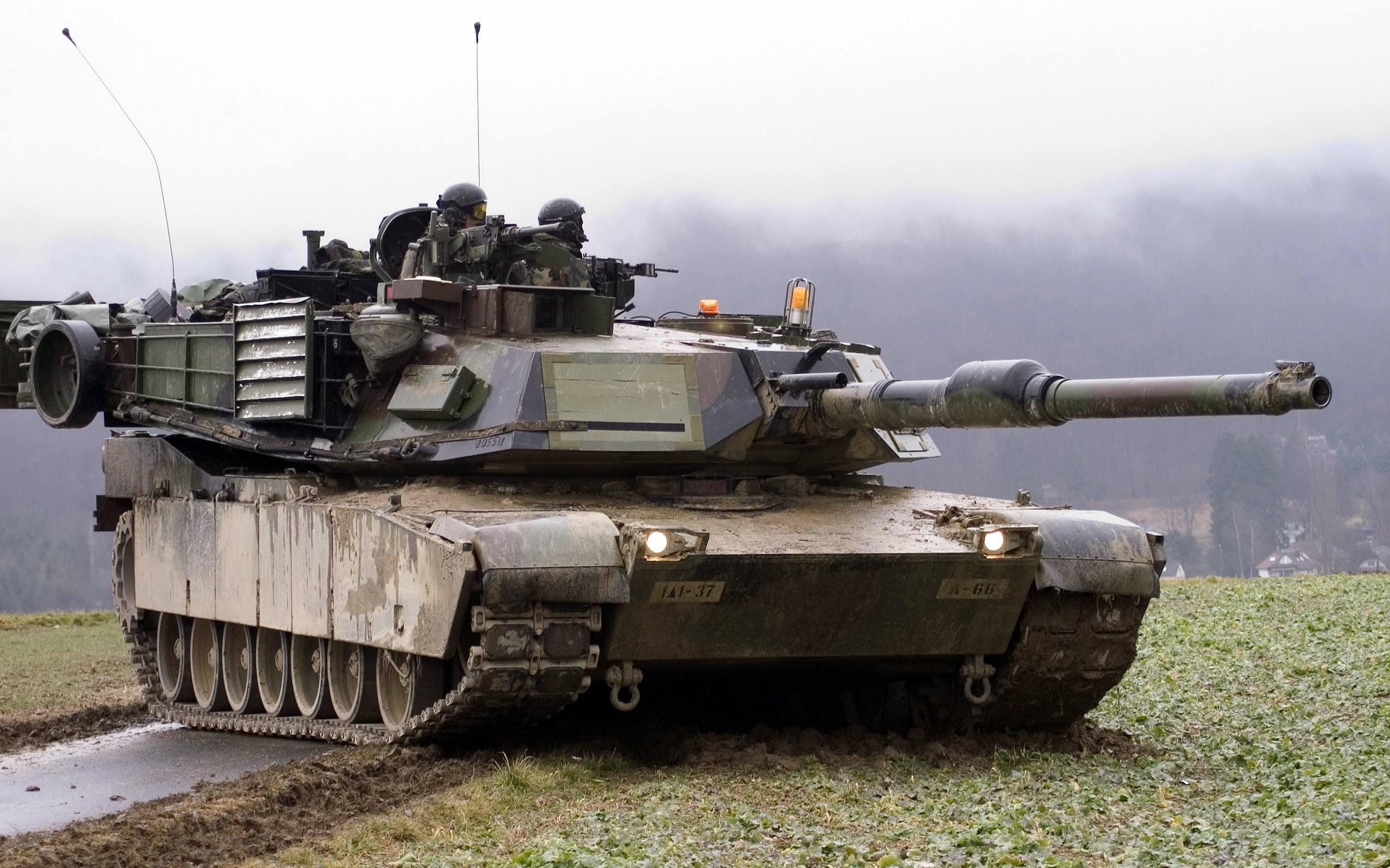 M1 Abrams tank in a muddy field HD Wallpaper