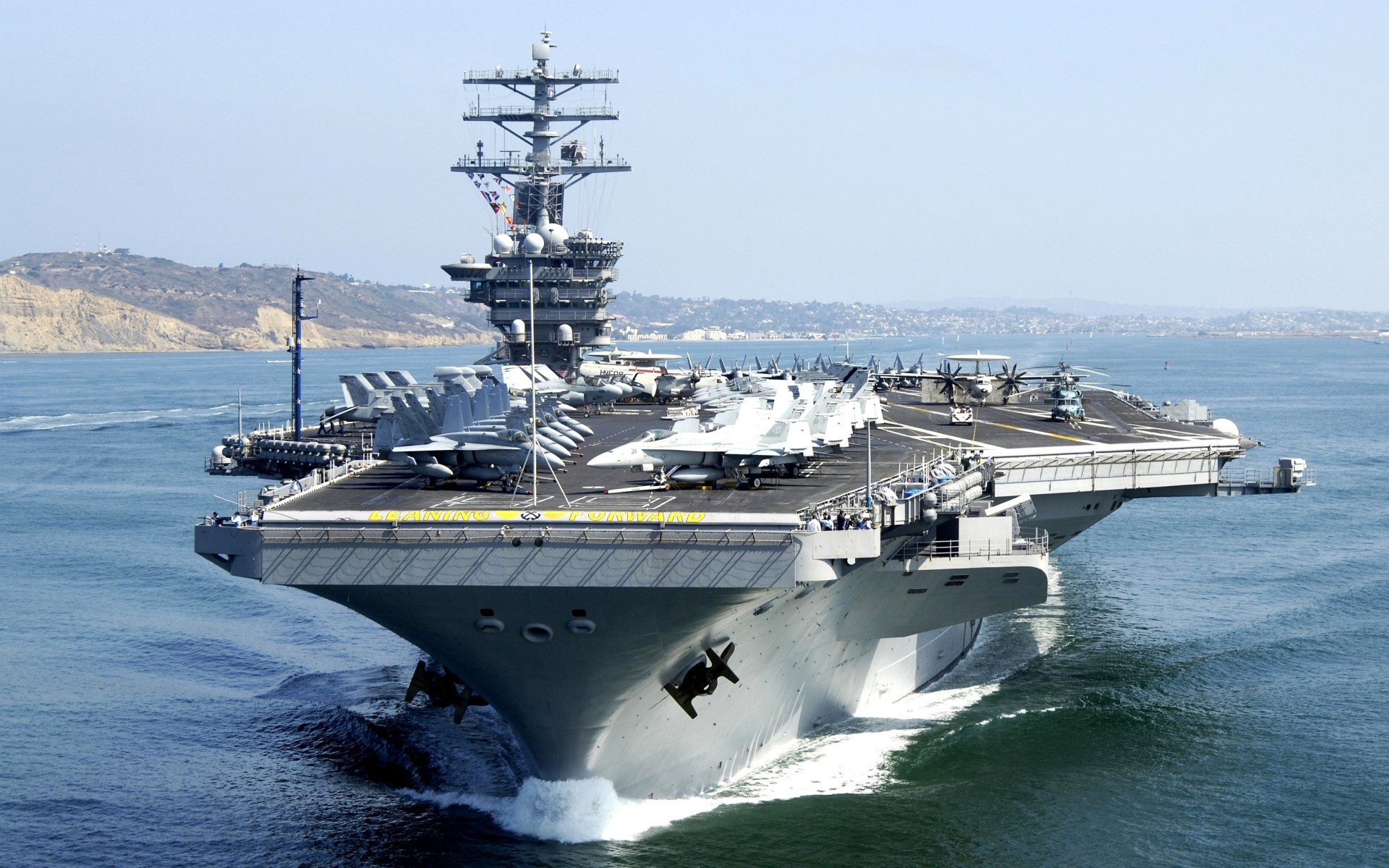 Aircraft carrier sailing in the ocean with airplanes on deck HD Wallpaper