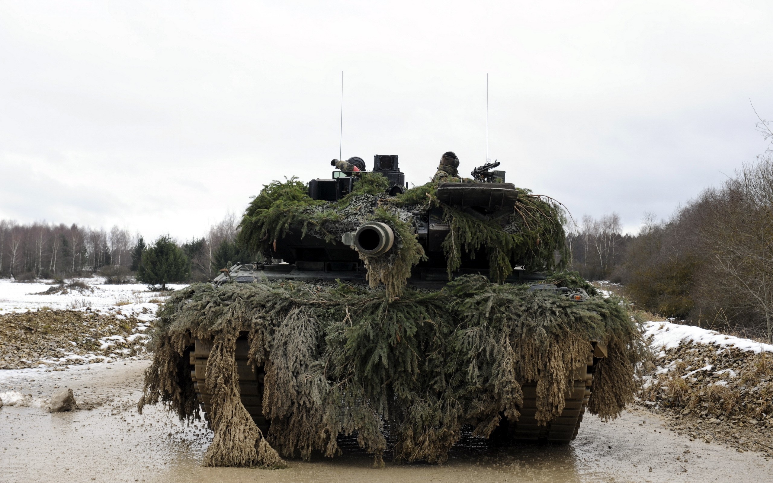 Camouflaged tank with soldiers in a muddy field HD Wallpaper