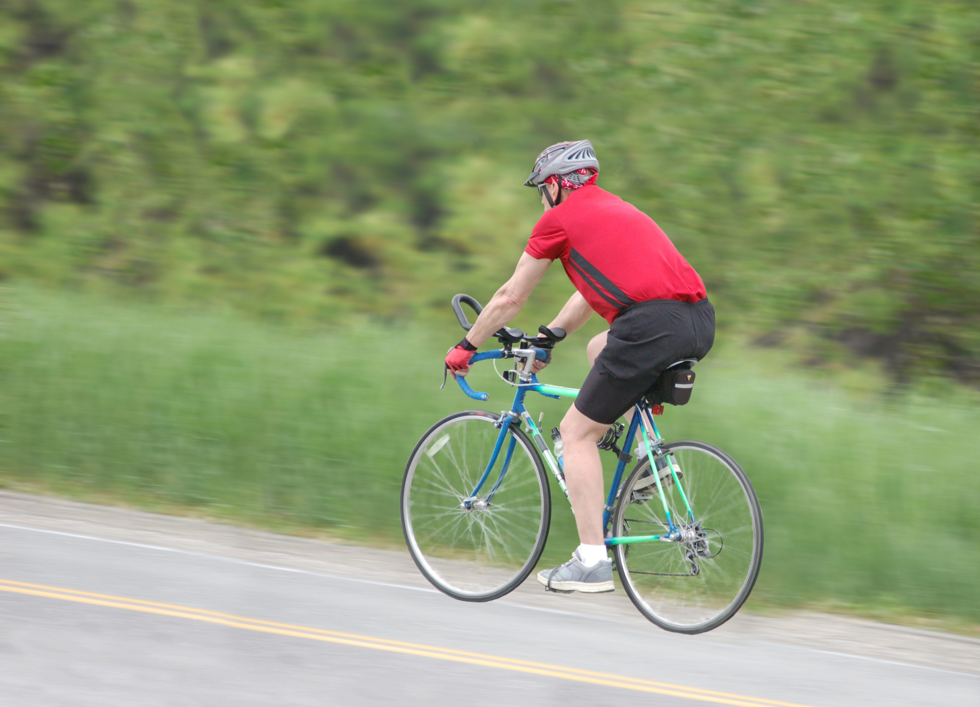 Man riding a bicycle on a road HD Wallpaper