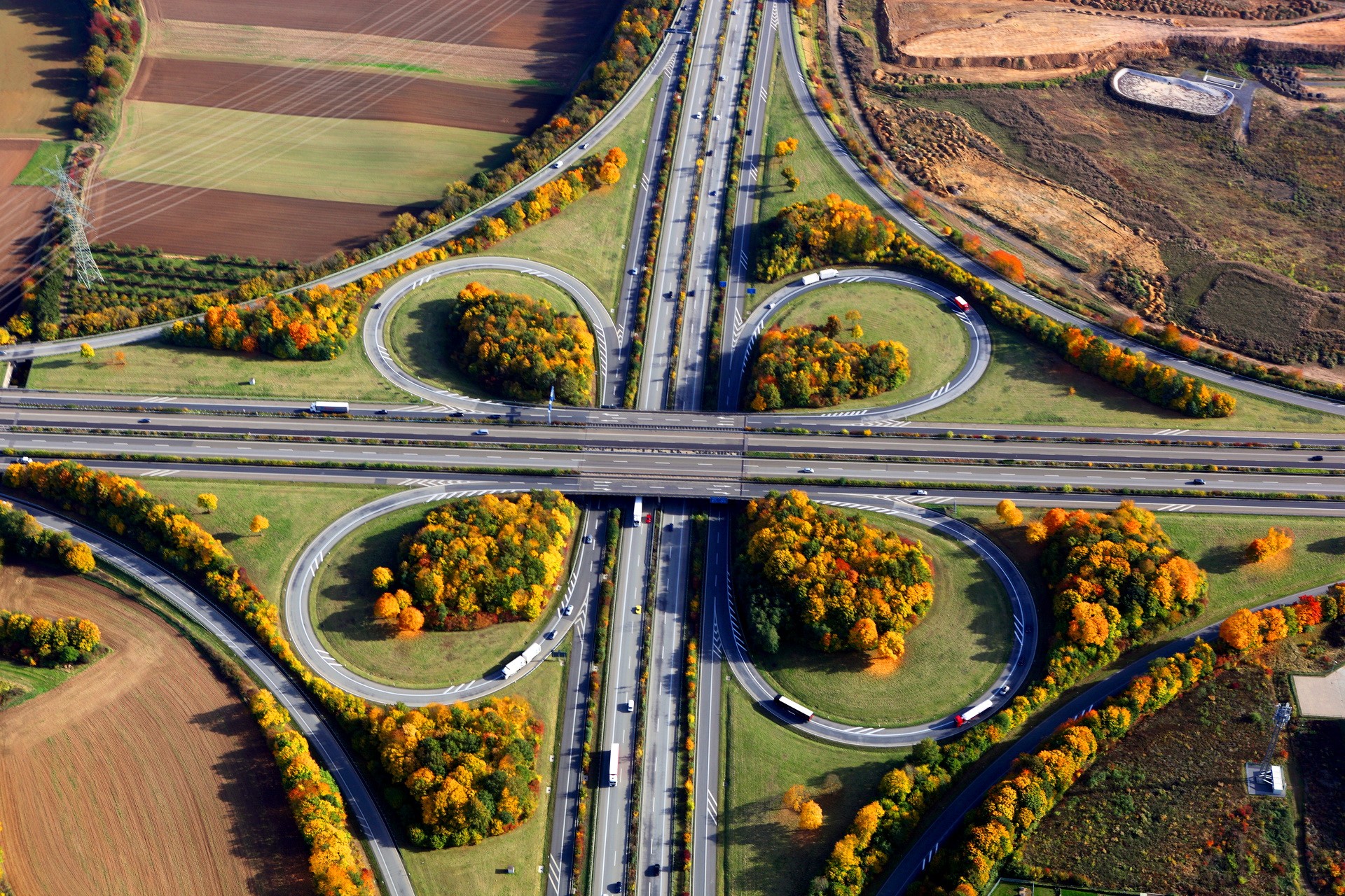 Aerial view of a highway interchange in autumn HD Wallpaper