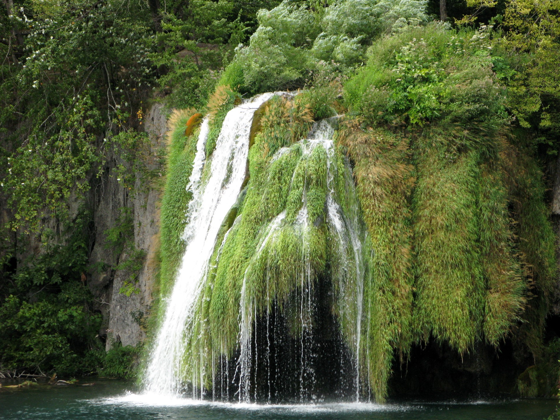 Waterfalls cascading over mossy rocks HD Wallpaper