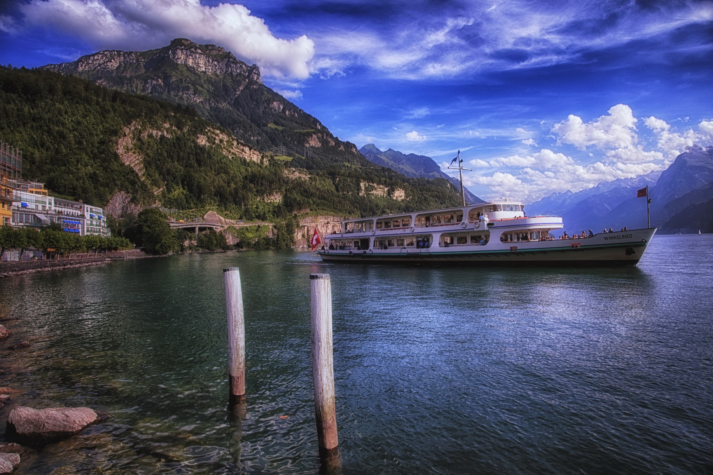 Passenger ship on a lake with mountains and buildings HD Wallpaper