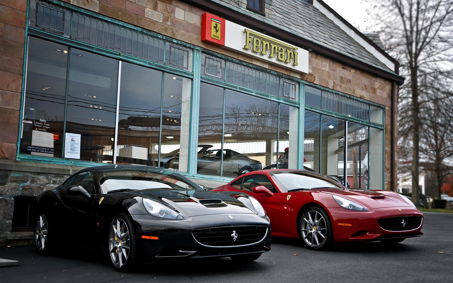 Two Ferrari cars parked outside a Ferrari dealership HD Wallpaper