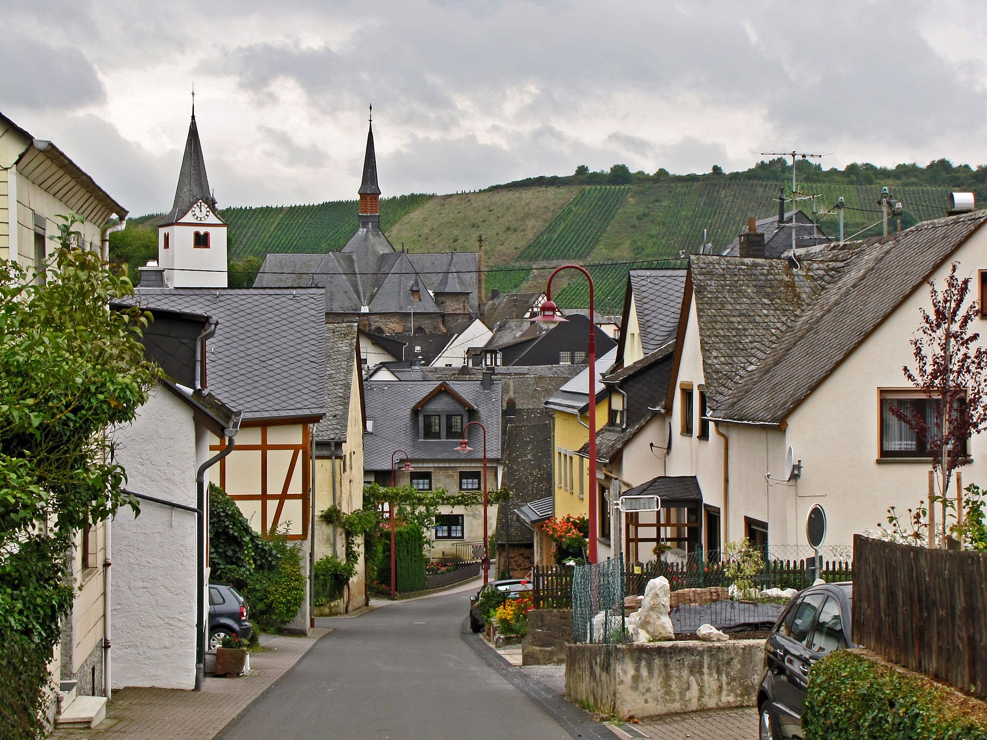 Village street with church and vineyards in Germany HD Wallpaper