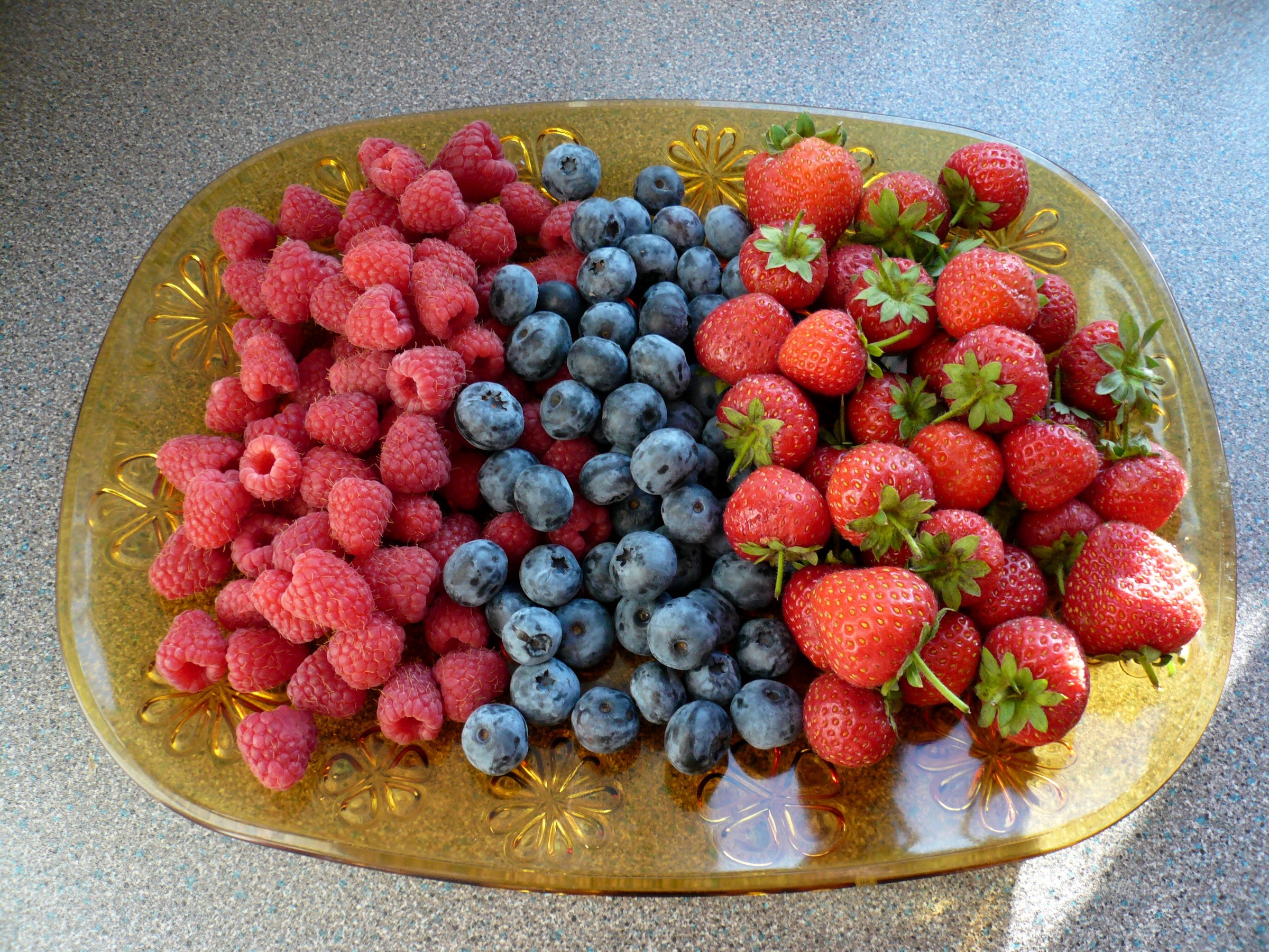A platter of fresh raspberries, blueberries, and strawberries HD Wallpaper