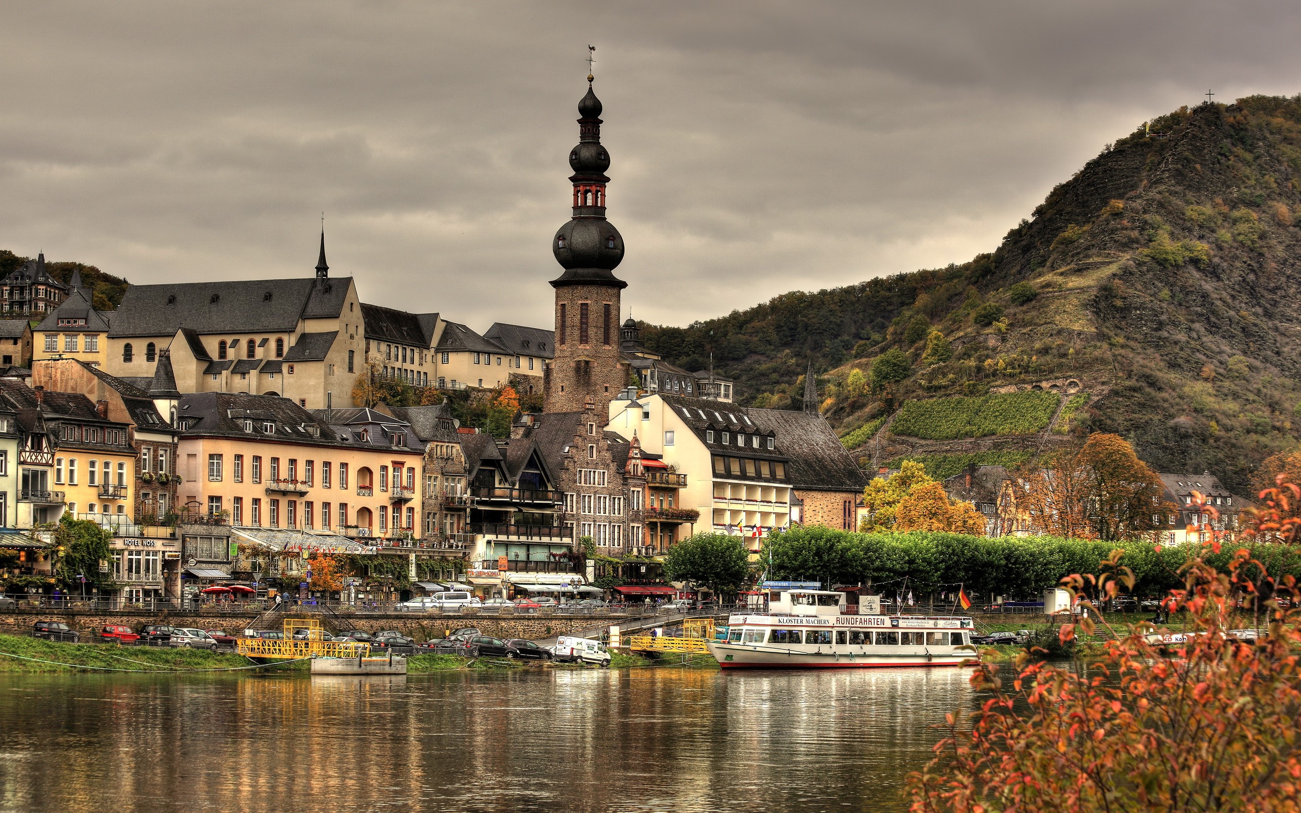 Town on a river with a church tower and a hill in Germany HD Wallpaper