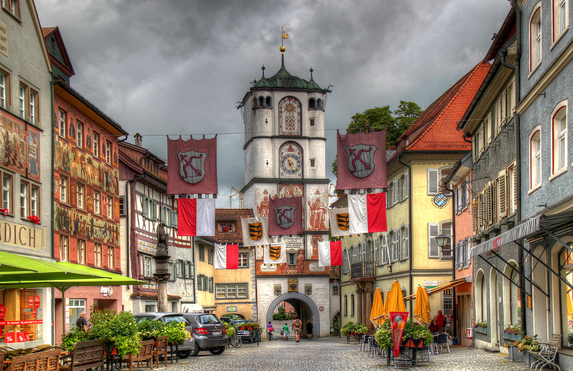Town square with clock tower and banners in Germany HD Wallpaper