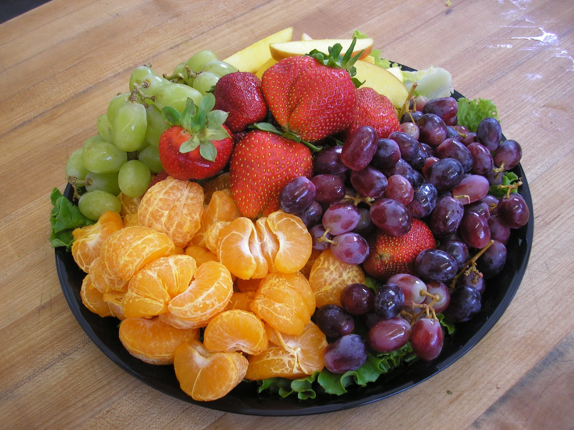 Fruit platter with grapes, strawberries, and tangerines HD Wallpaper