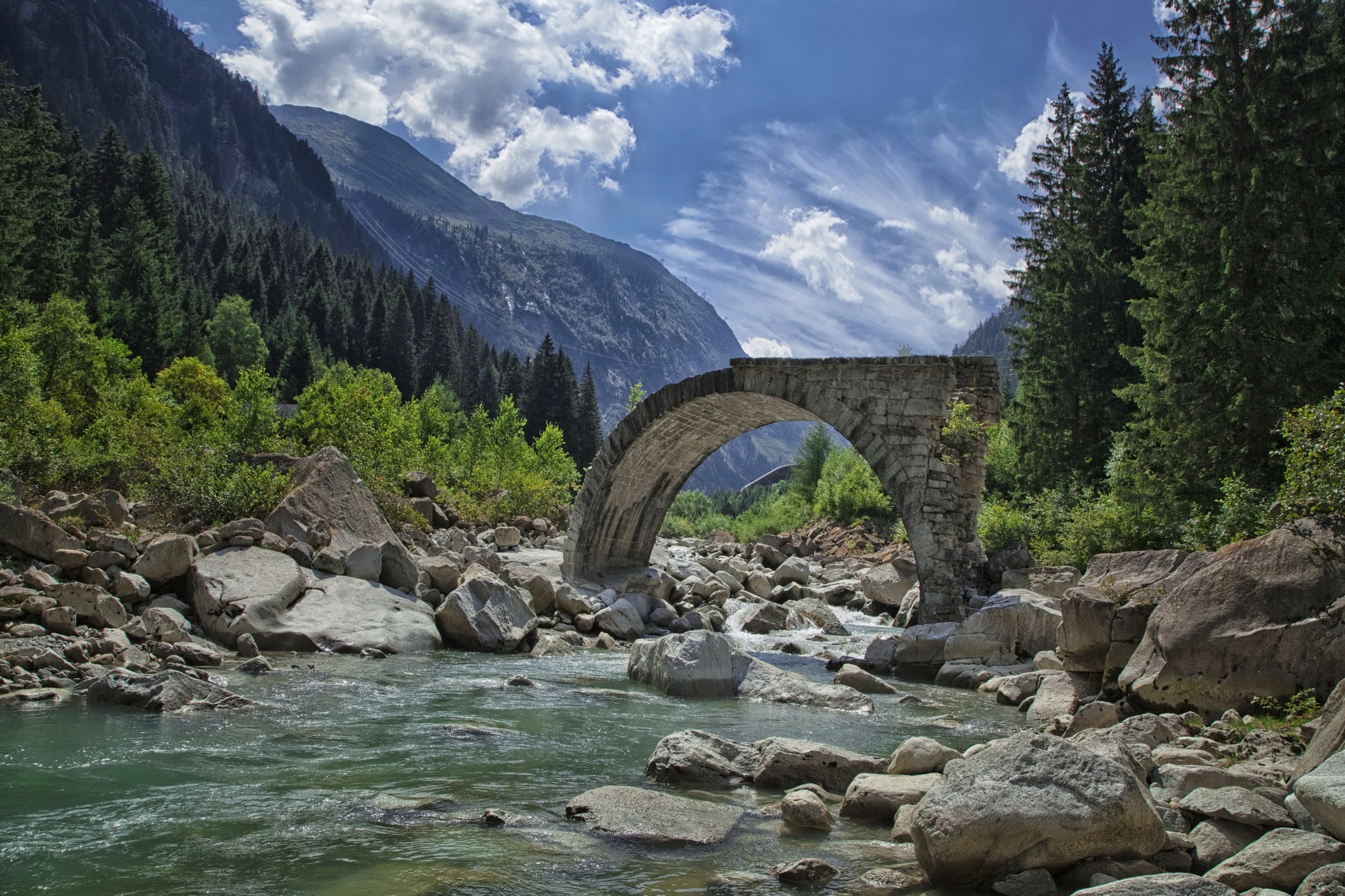 Stone bridge over a rocky river in the mountains HD Wallpaper