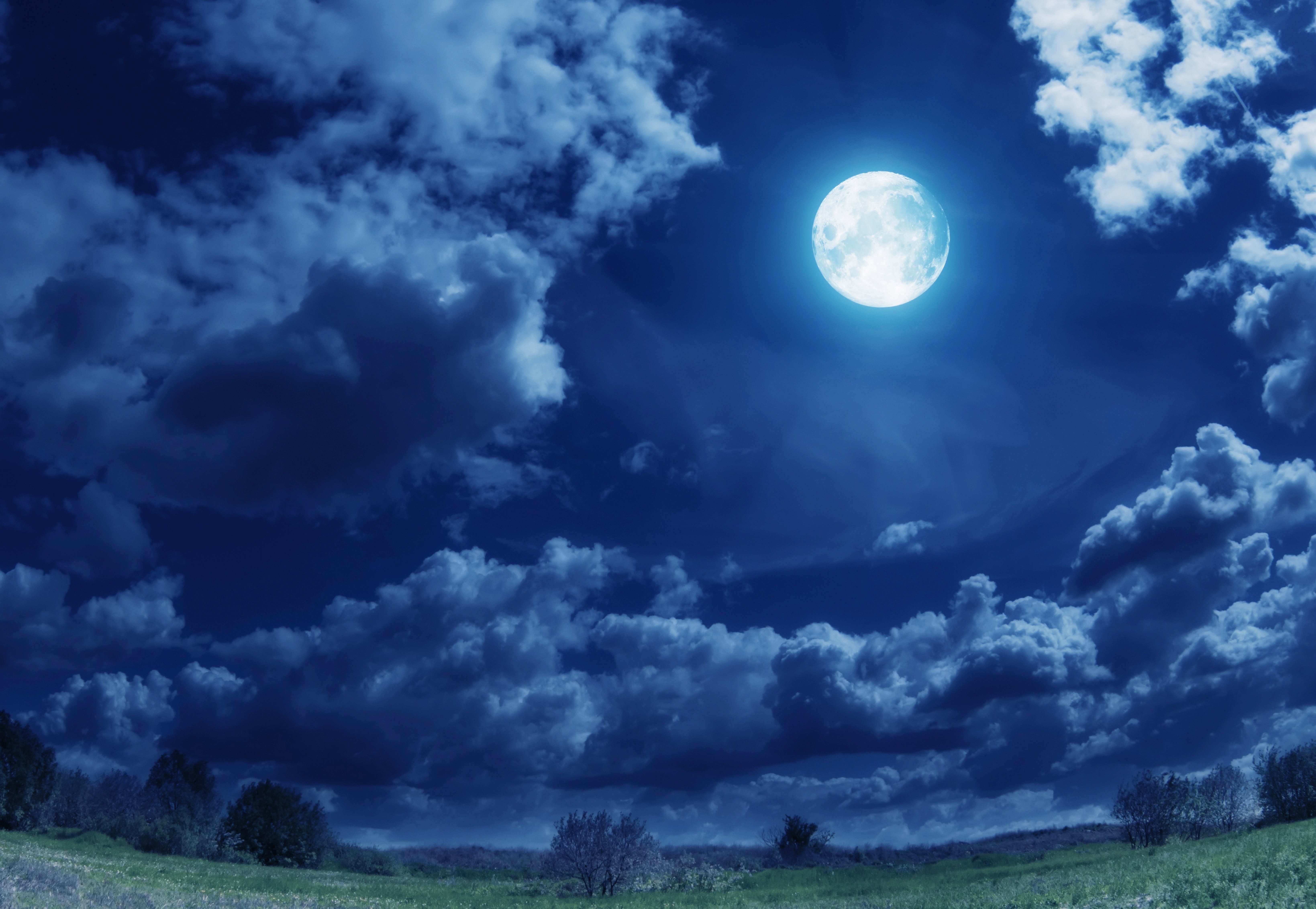 Full moon in a cloudy night sky over a field HD Wallpaper
