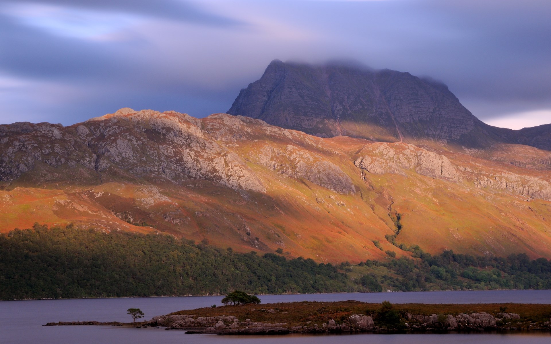 Mountain range overlooking a lake with a small island HD Wallpaper