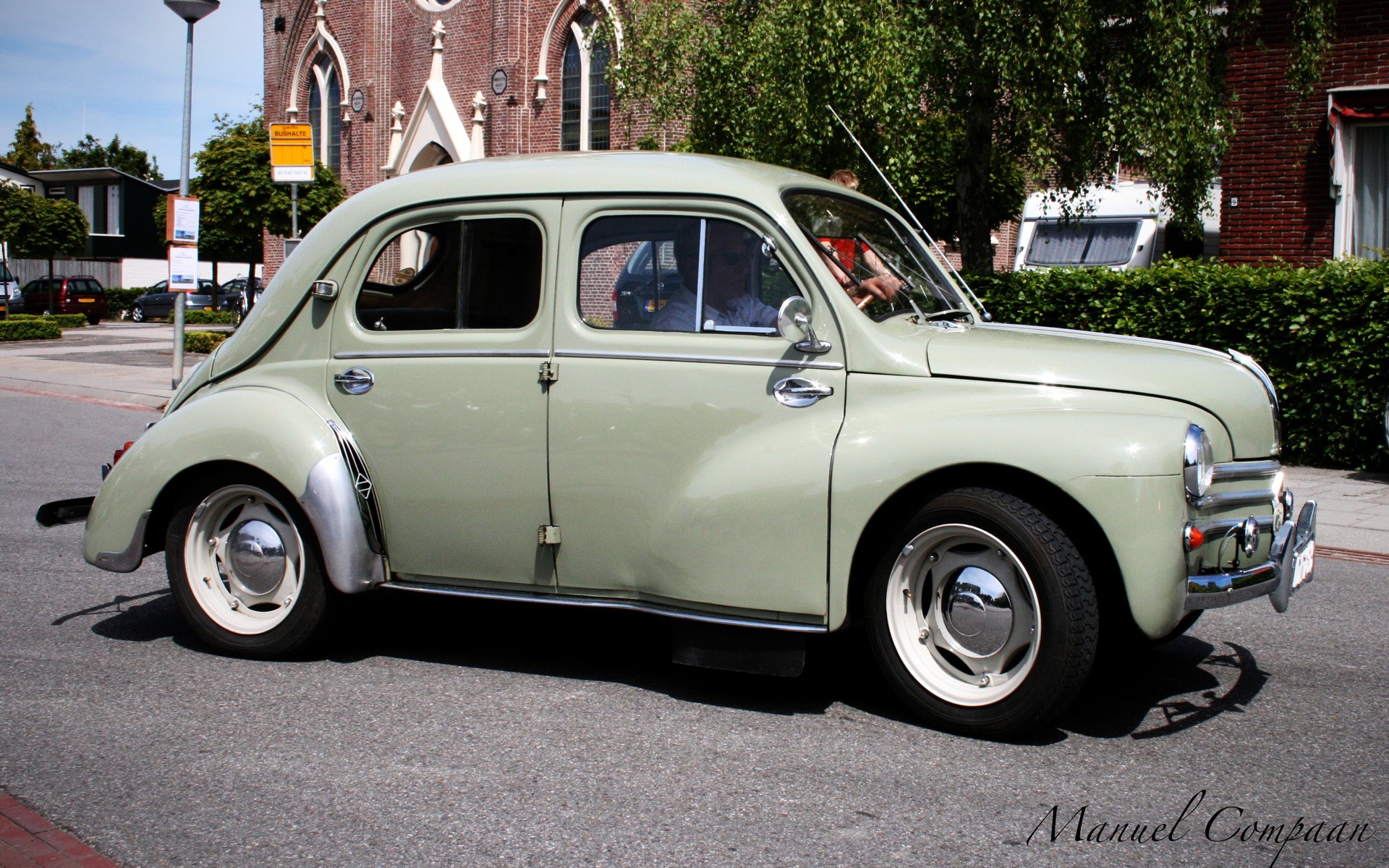 1956 Renault 4CV driving on a street HD Wallpaper