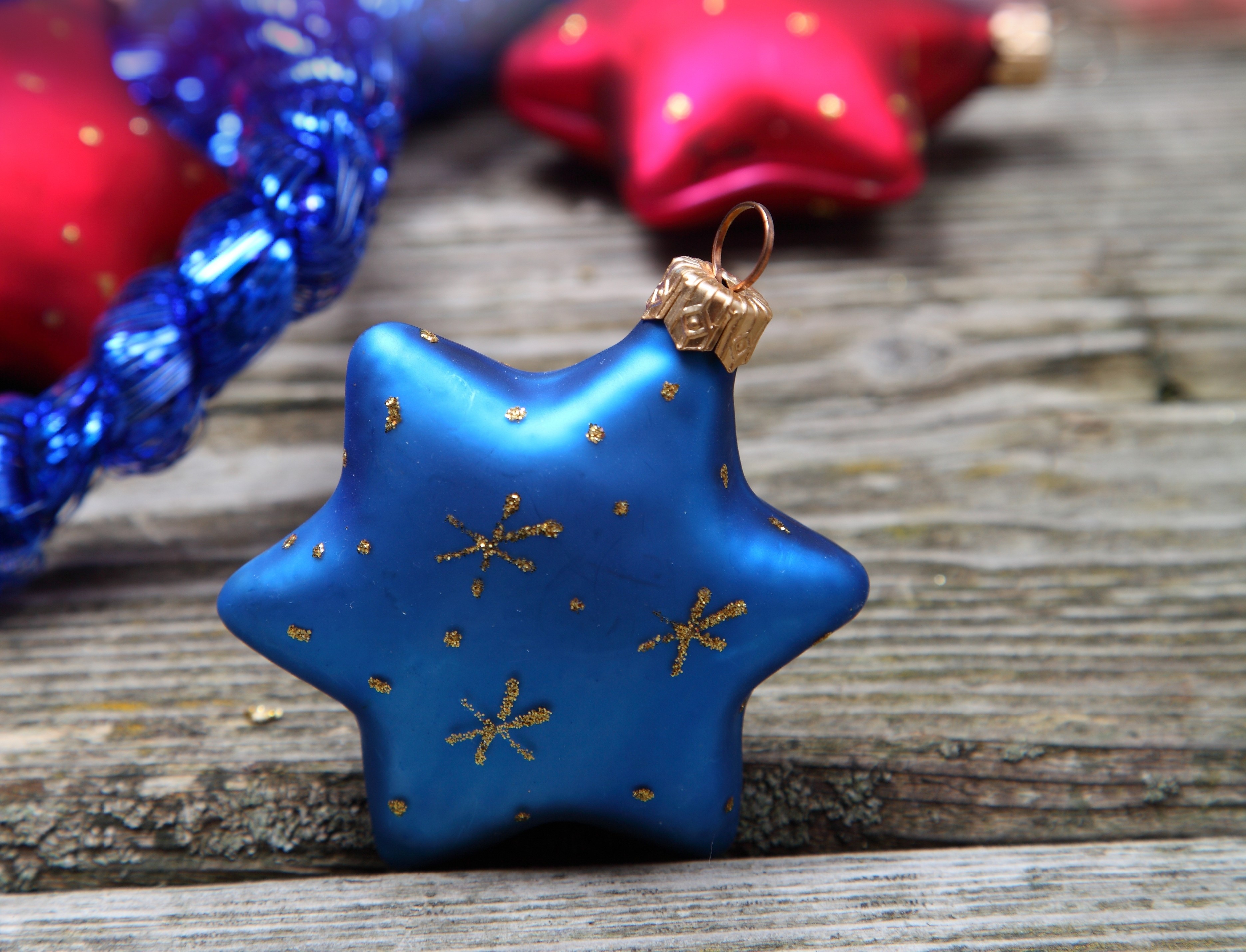 Blue star Christmas ornament on wooden surface HD Wallpaper