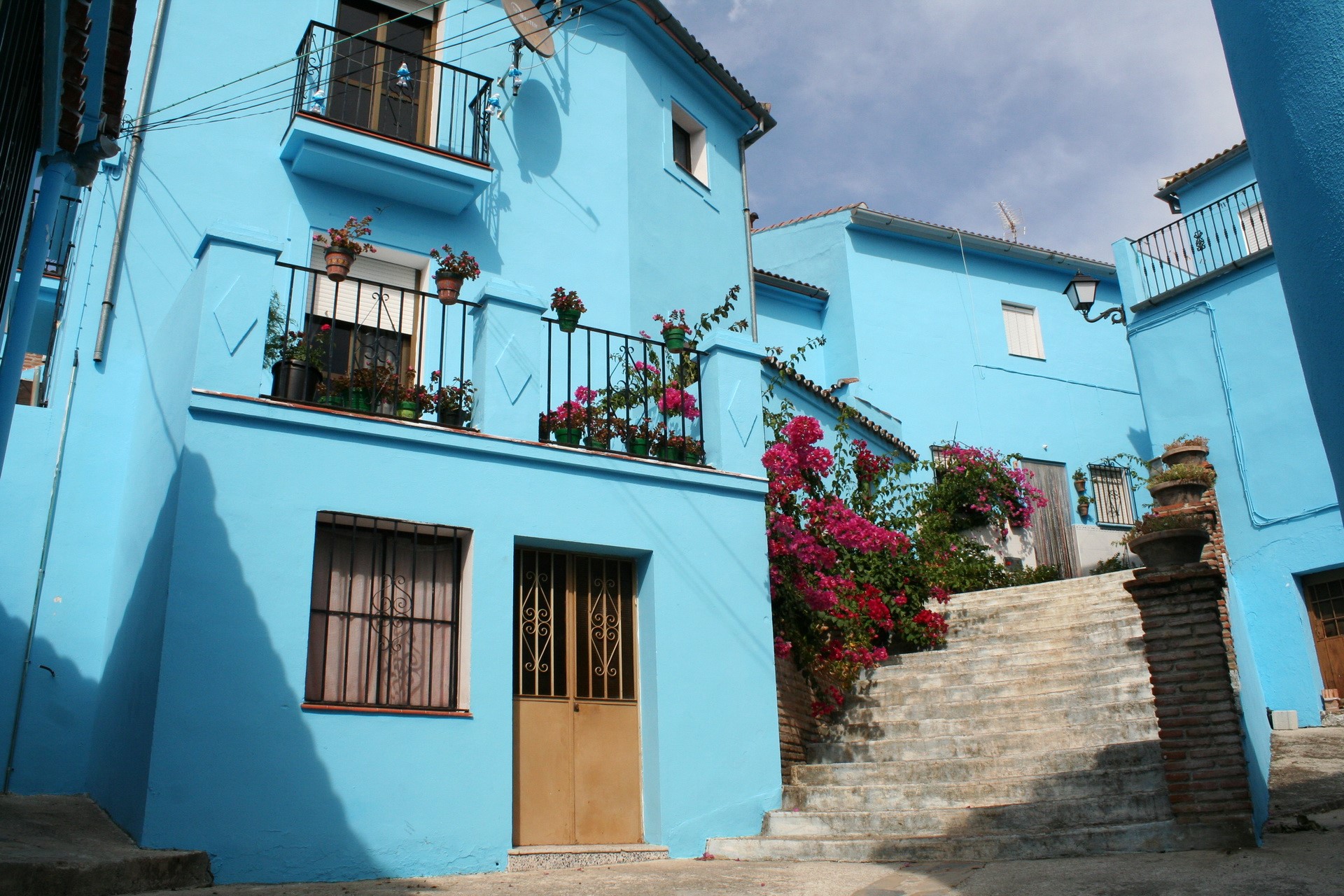 Blue houses with balconies and flowers in Spain HD Wallpaper