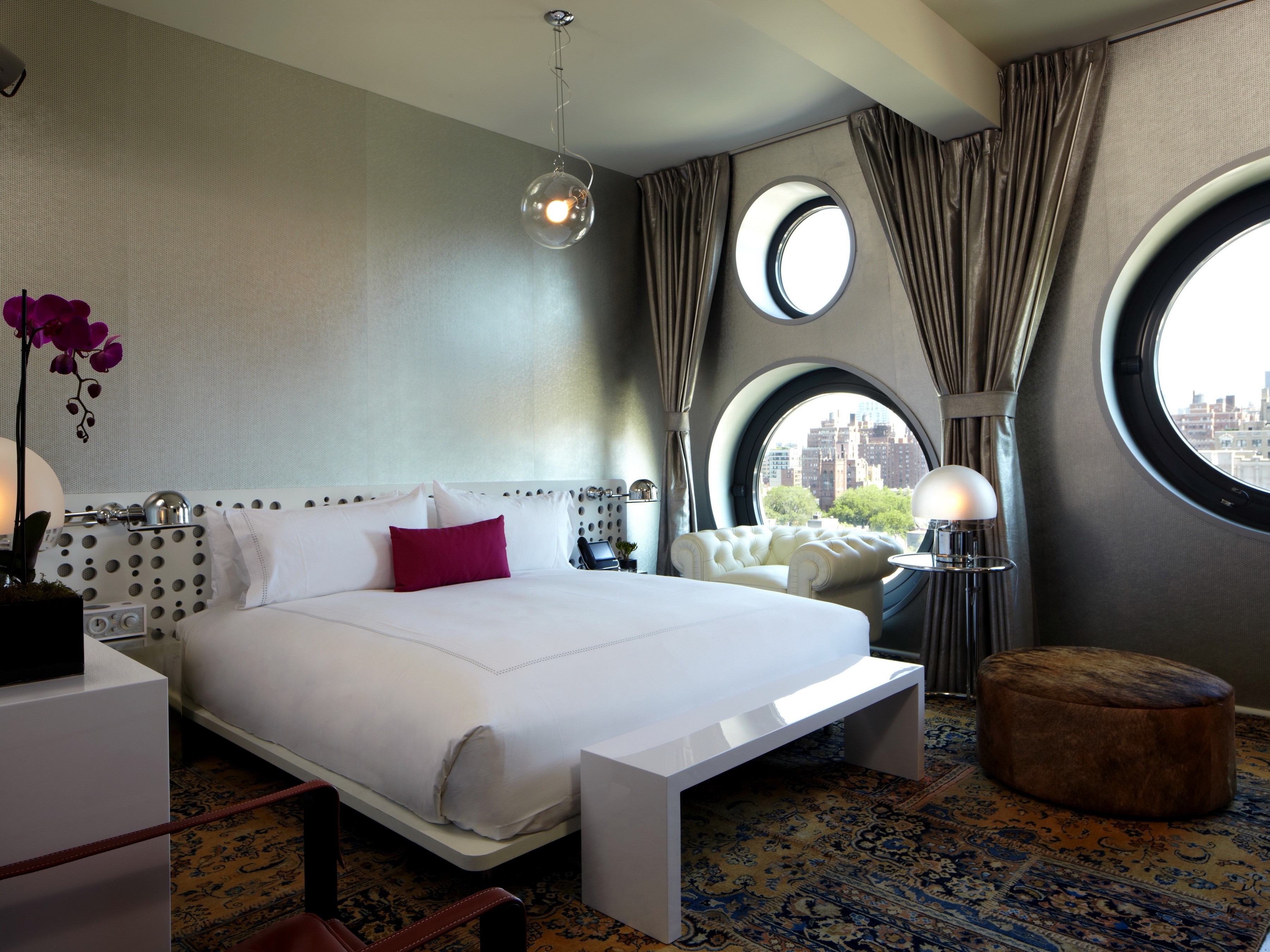 Modern bedroom with circular windows and city view HD Wallpaper