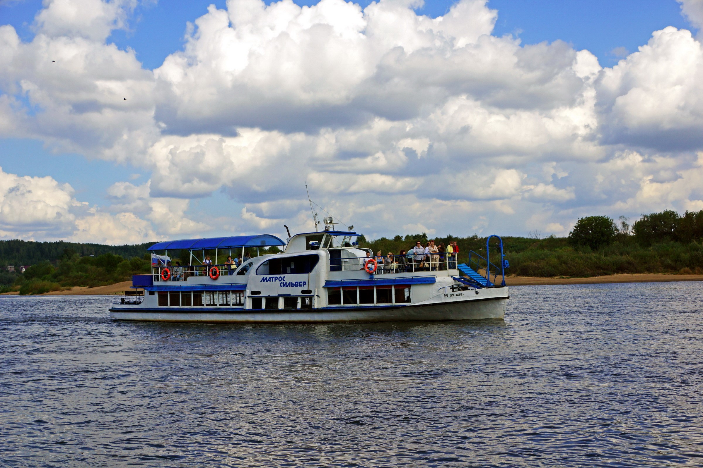 Passenger boat sailing on a river under clouds HD Wallpaper