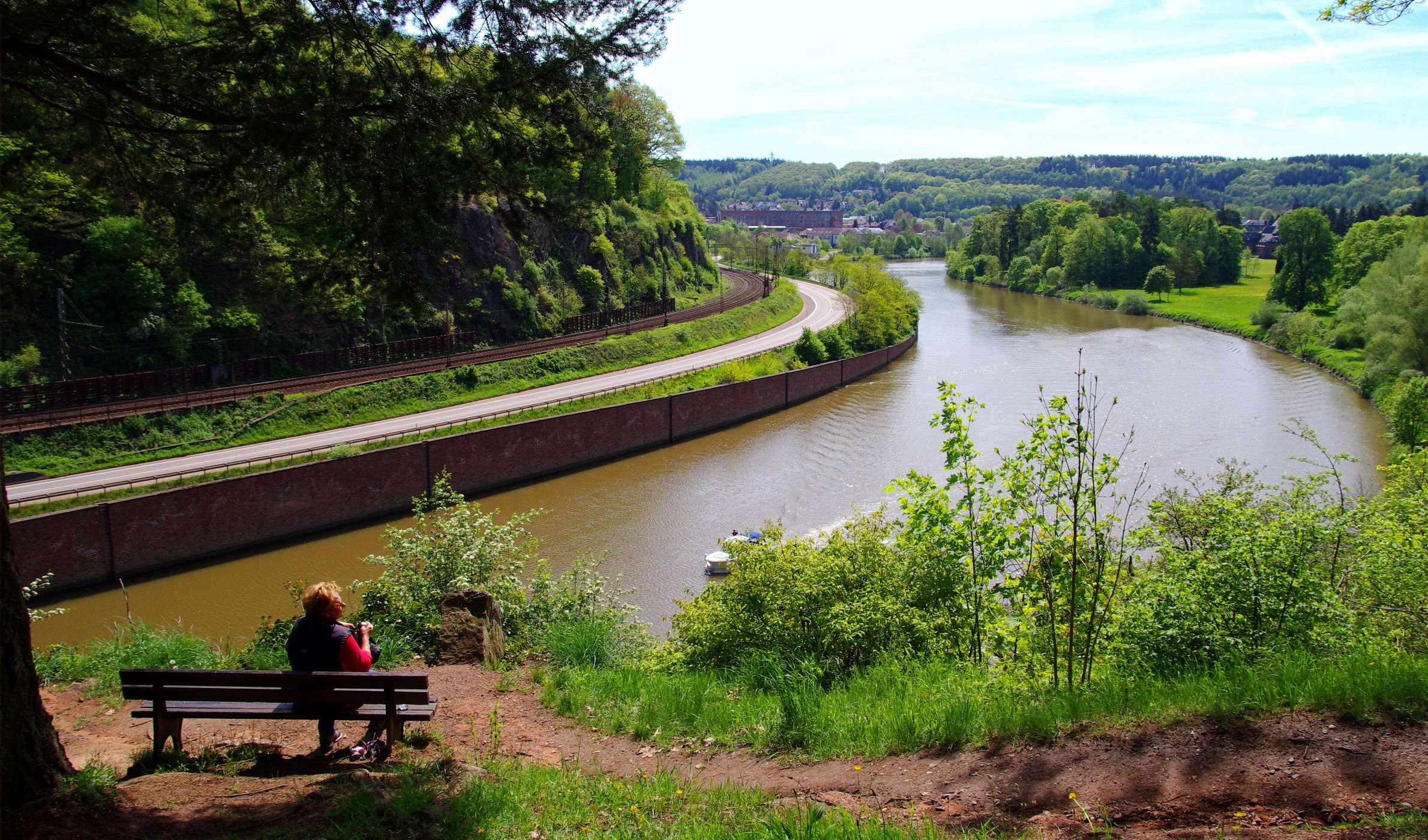 Woman on bench overlooking river and canal in Germany HD Wallpaper