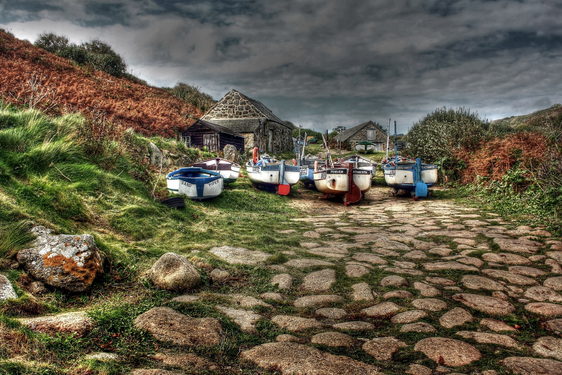 Boats on a cobblestone path near stone buildings HD Wallpaper