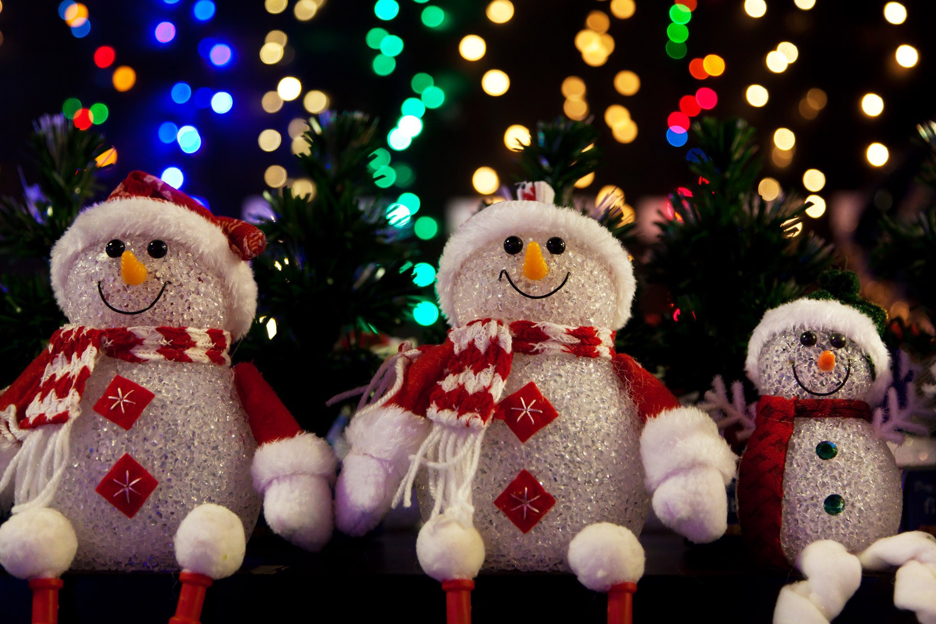 Three Christmas snowmen with festive lights HD Wallpaper