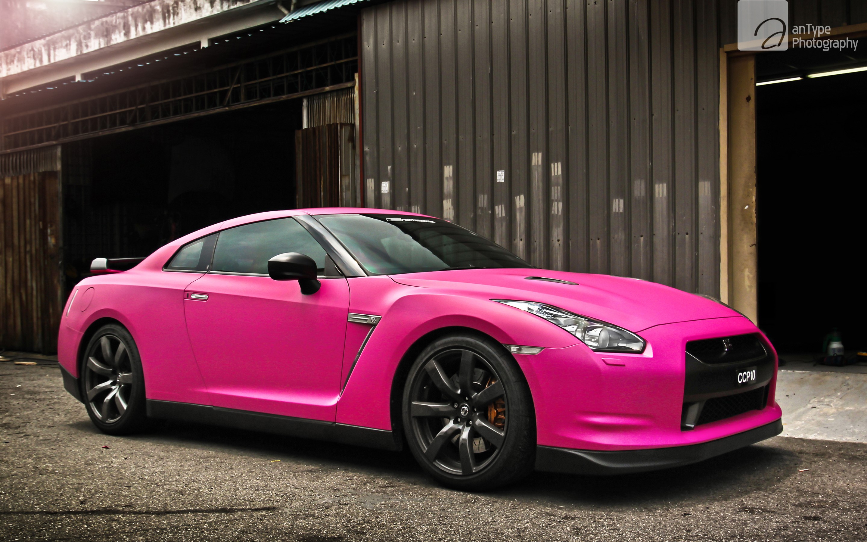 Pink Nissan GT-R parked outside a building HD Wallpaper