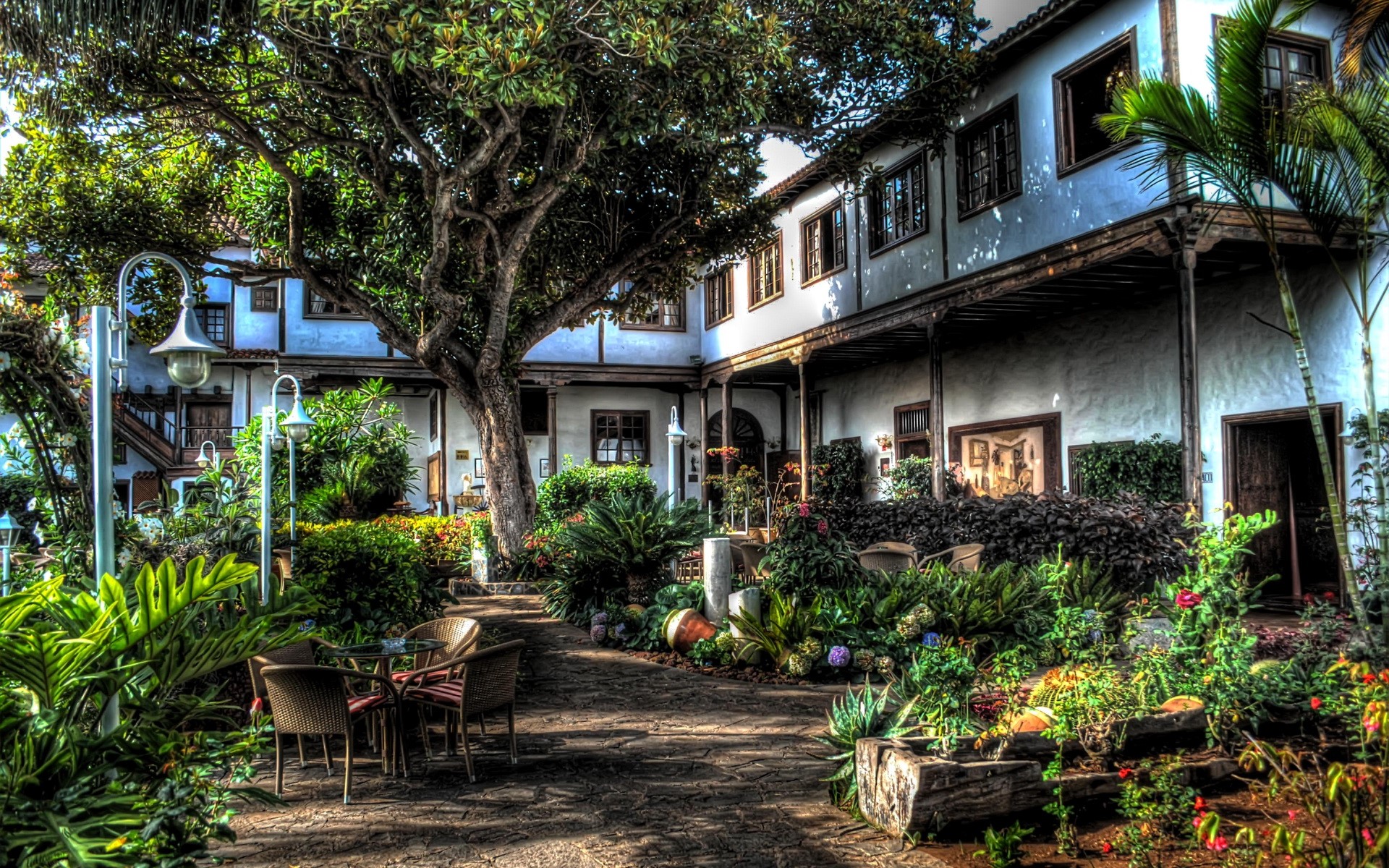 Courtyard with lush garden and white building in Canary Islands HD Wallpaper
