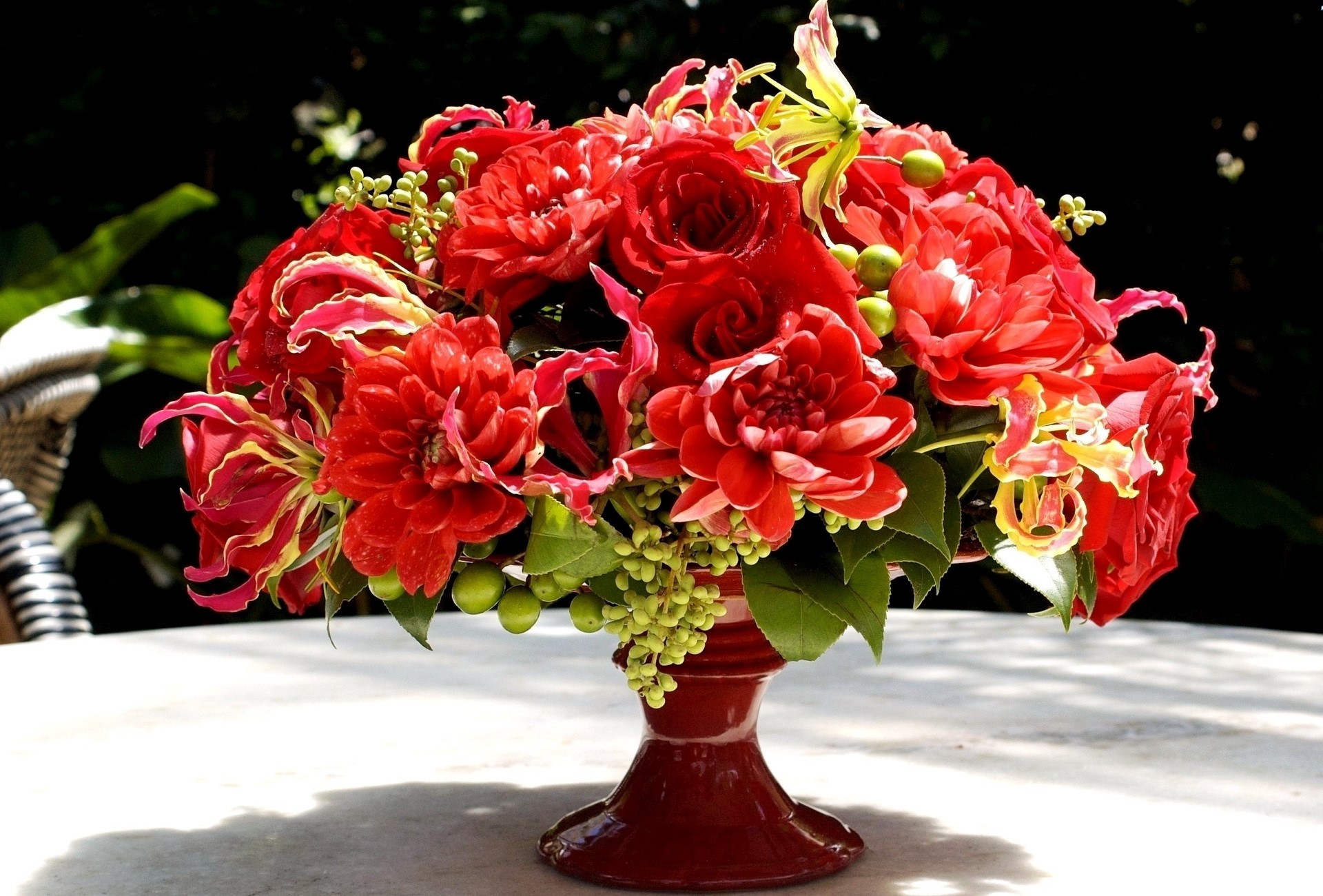 Red floral arrangement in a dark vase HD Wallpaper