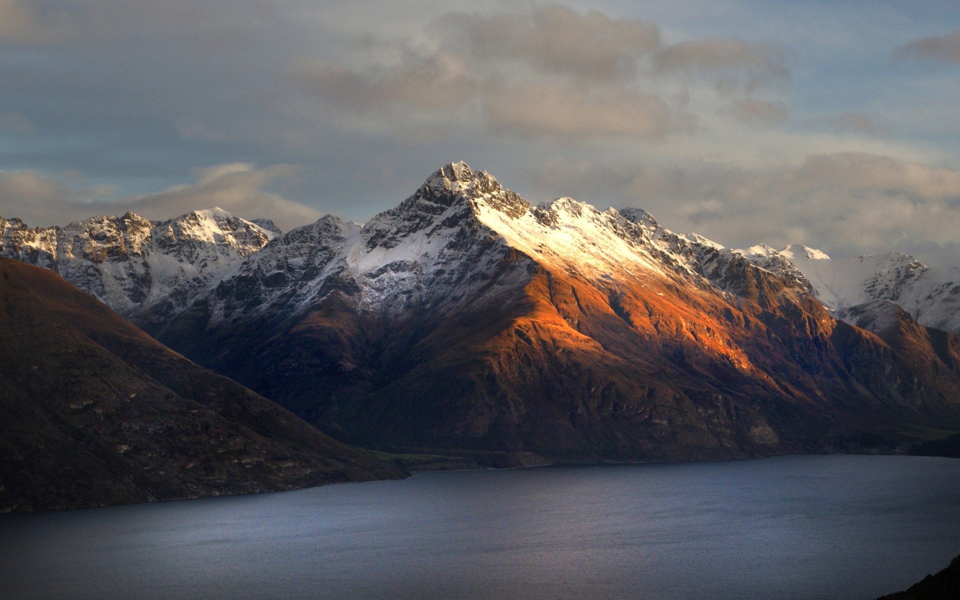 Snow-capped mountains over a lake at sunset HD Wallpaper