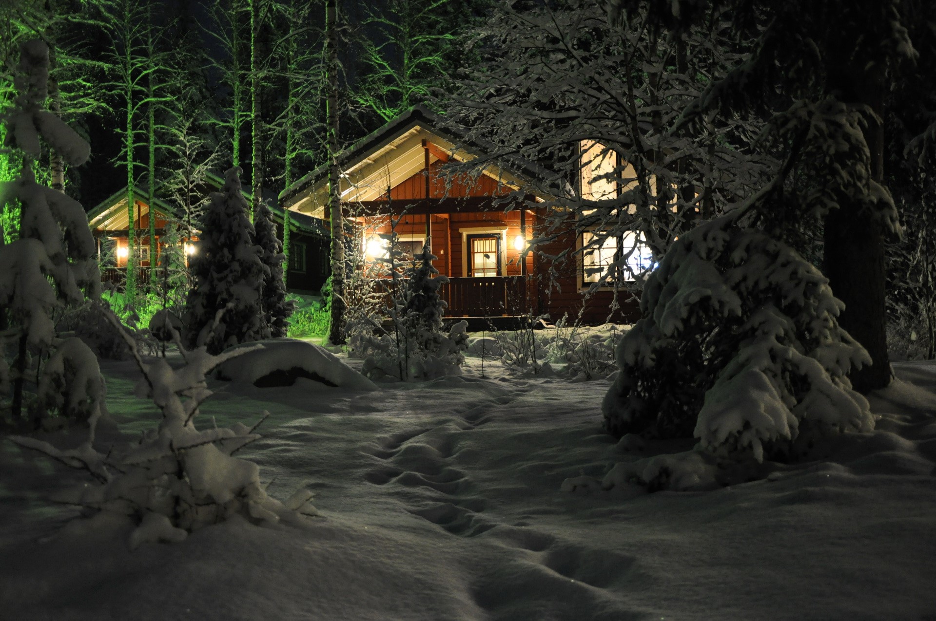 Cozy cabins in a snowy forest at night HD Wallpaper
