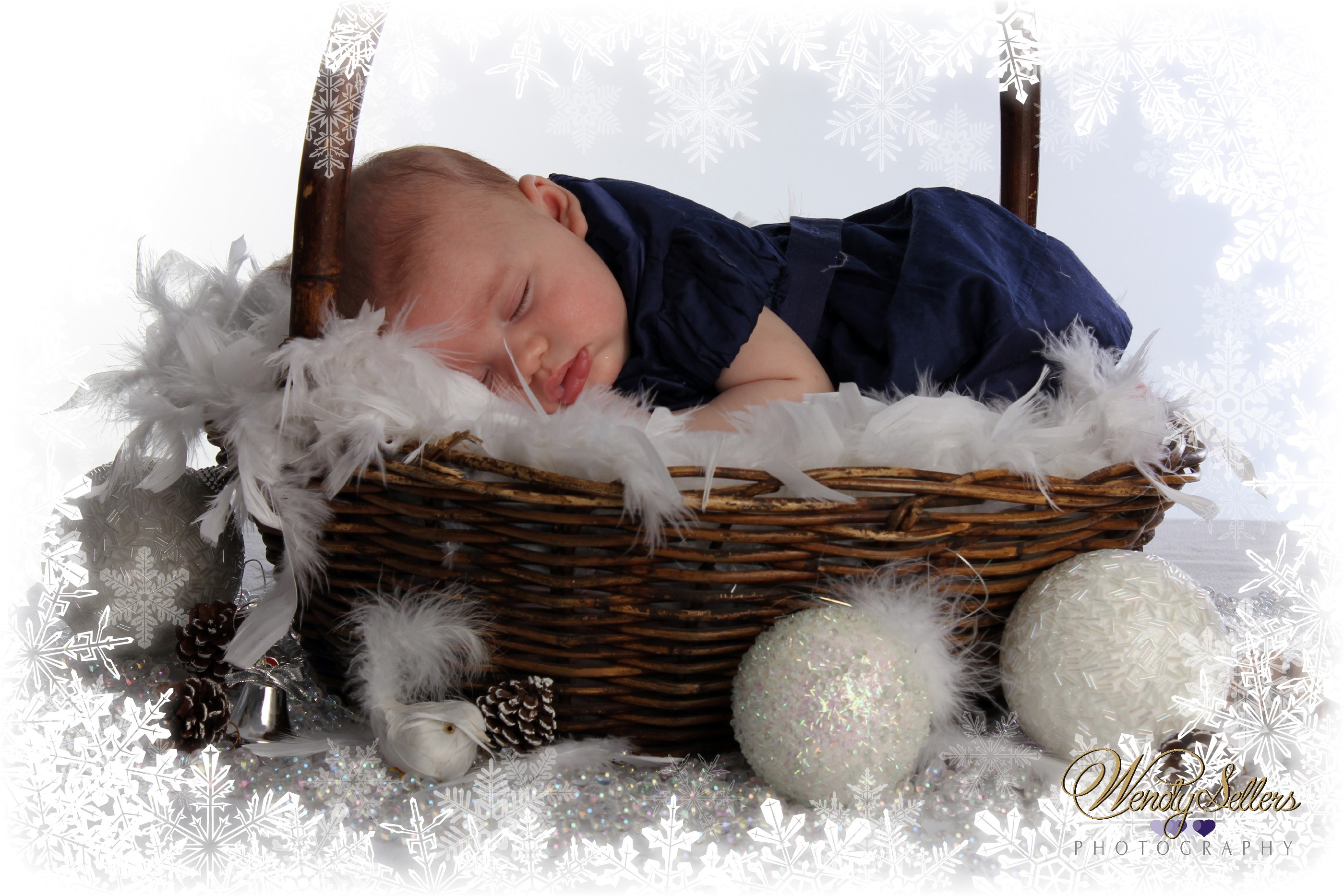Baby sleeping in a wicker basket with Christmas decorations HD Wallpaper
