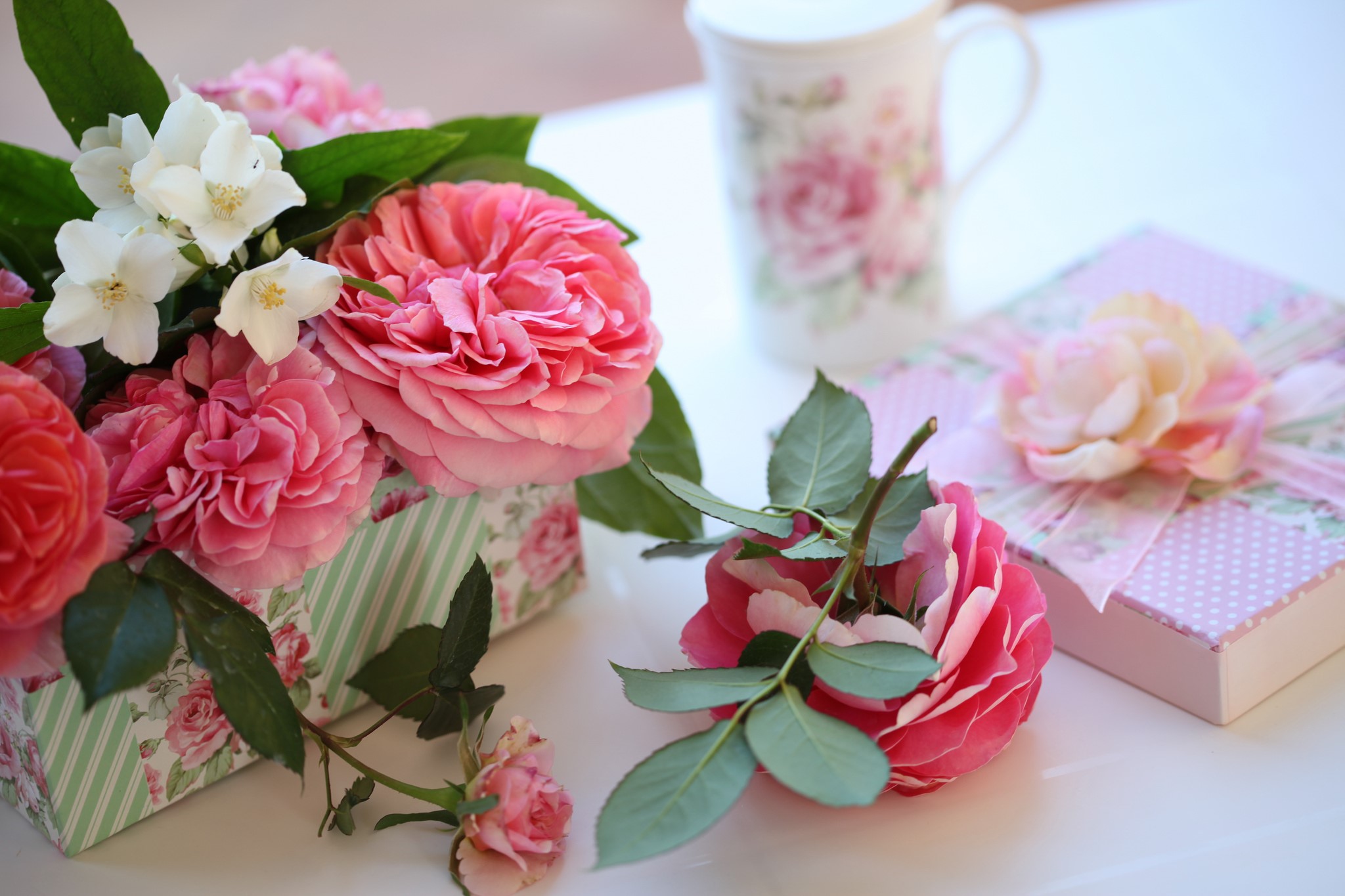 Pink roses and jasmine in a box with gifts and a mug HD Wallpaper