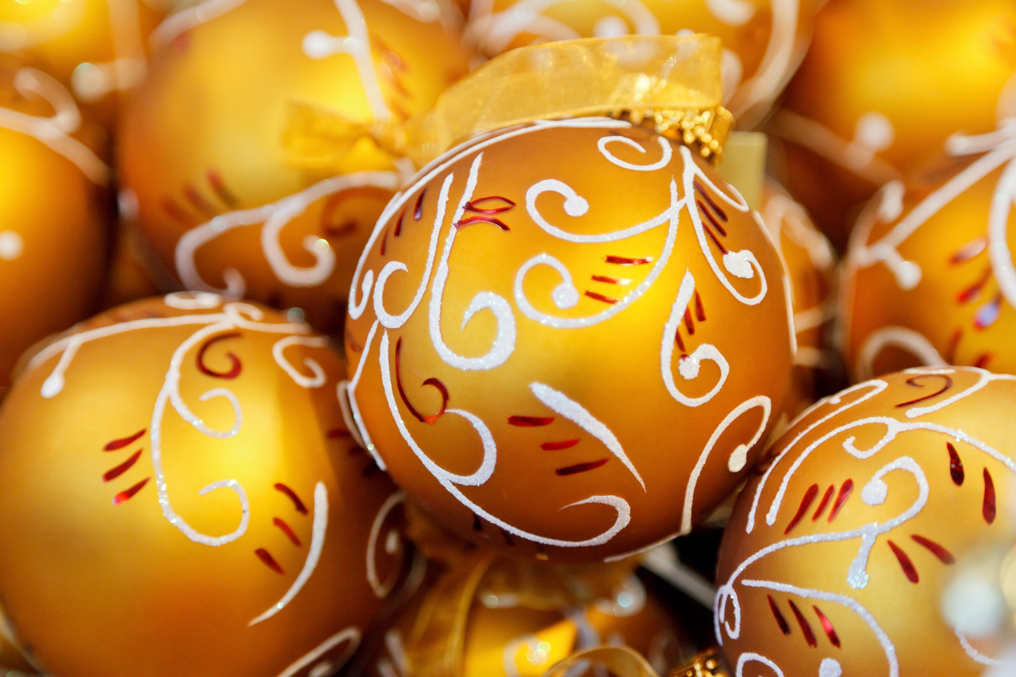 Golden Christmas ornaments with white swirls HD Wallpaper