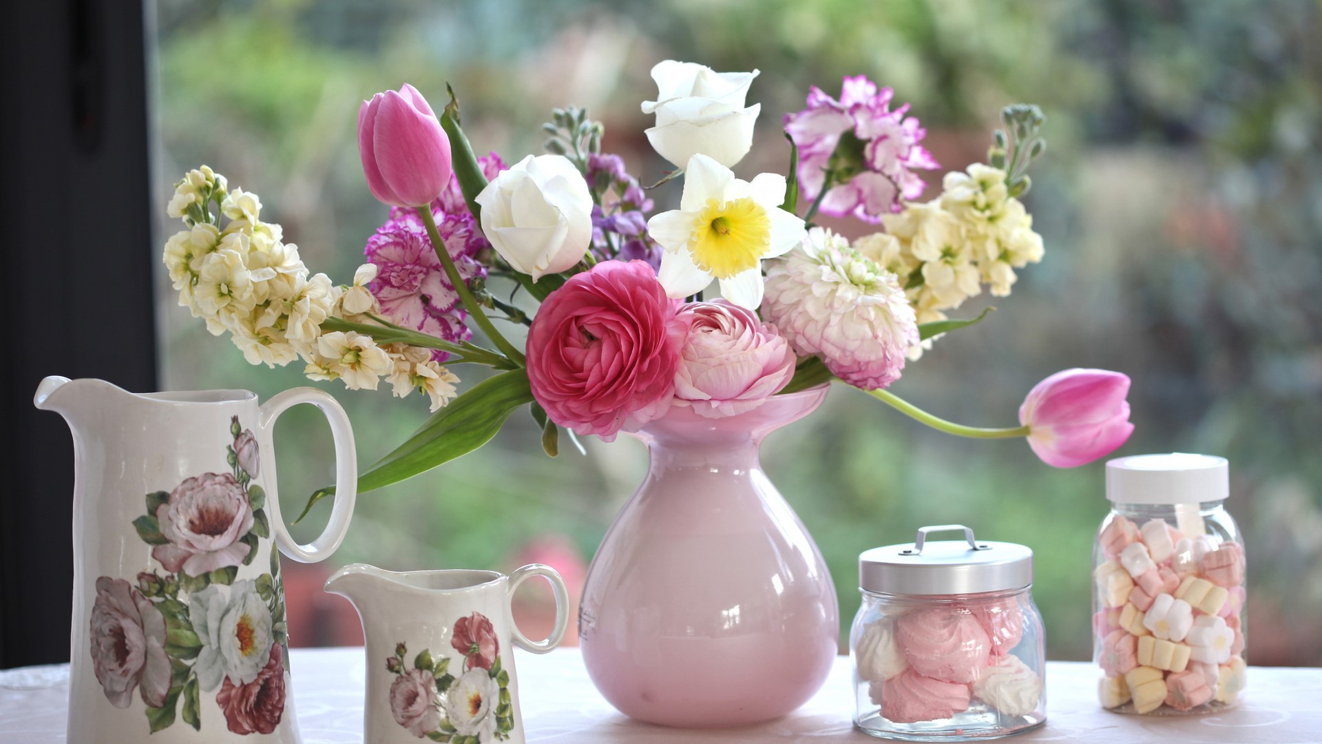 Bouquet of flowers in a pink vase with jars of marshmallows HD Wallpaper