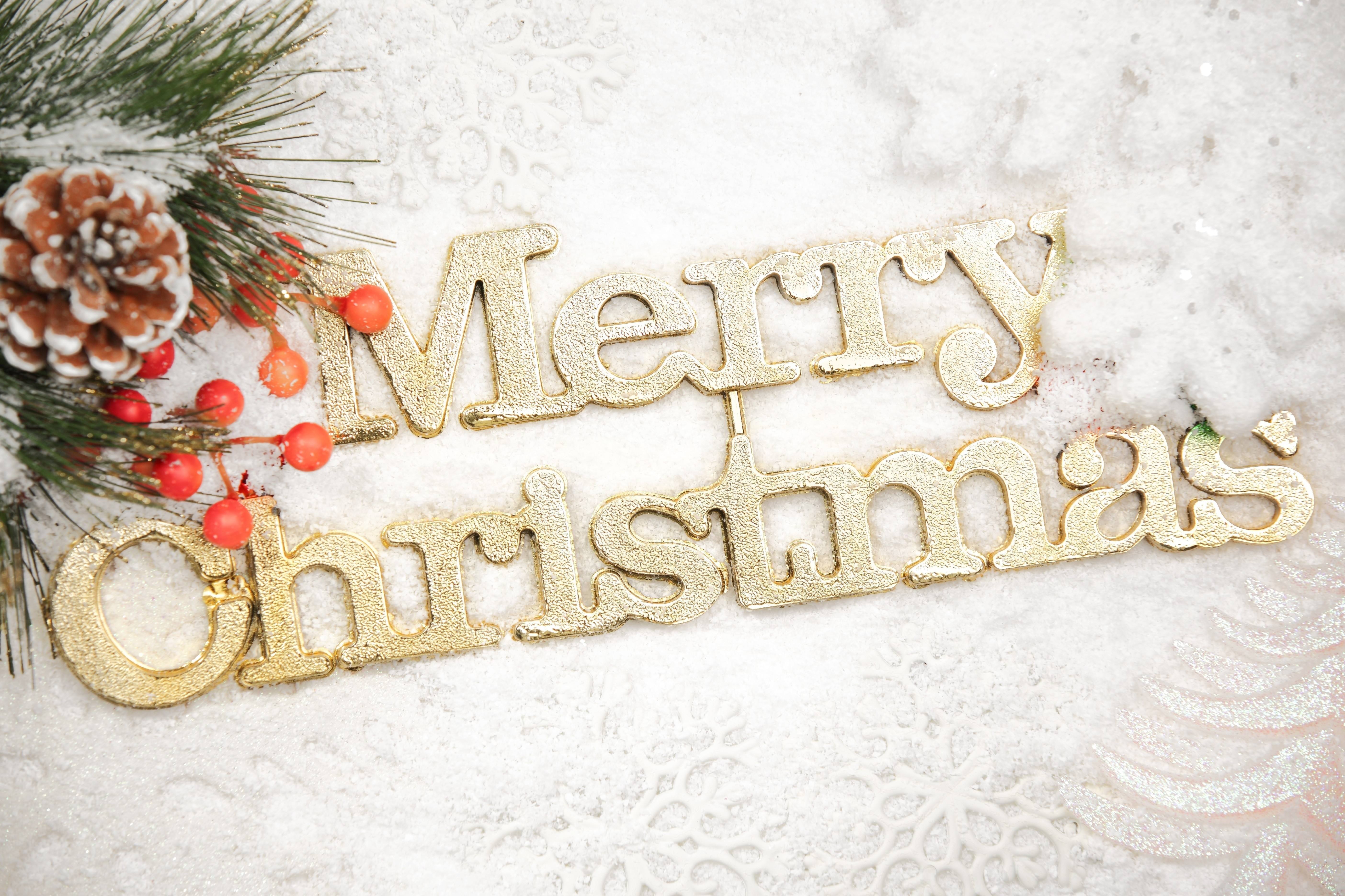 Merry Christmas golden text with pine cone and berries HD Wallpaper