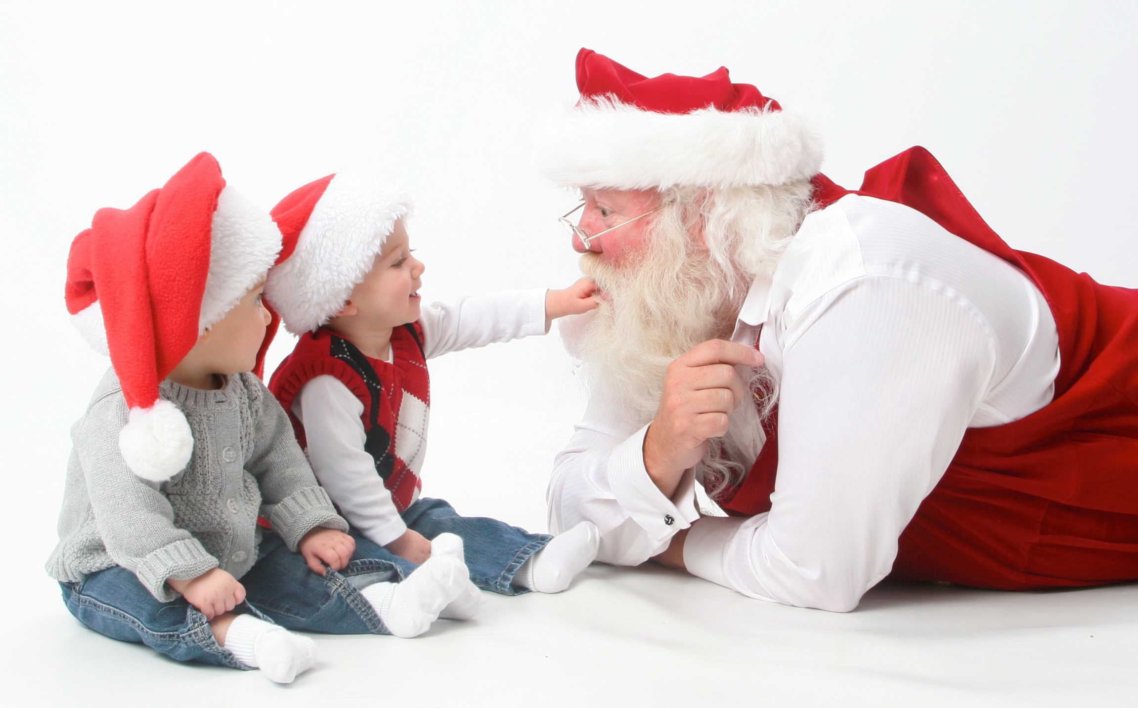 Santa Claus with two babies wearing Christmas hats HD Wallpaper