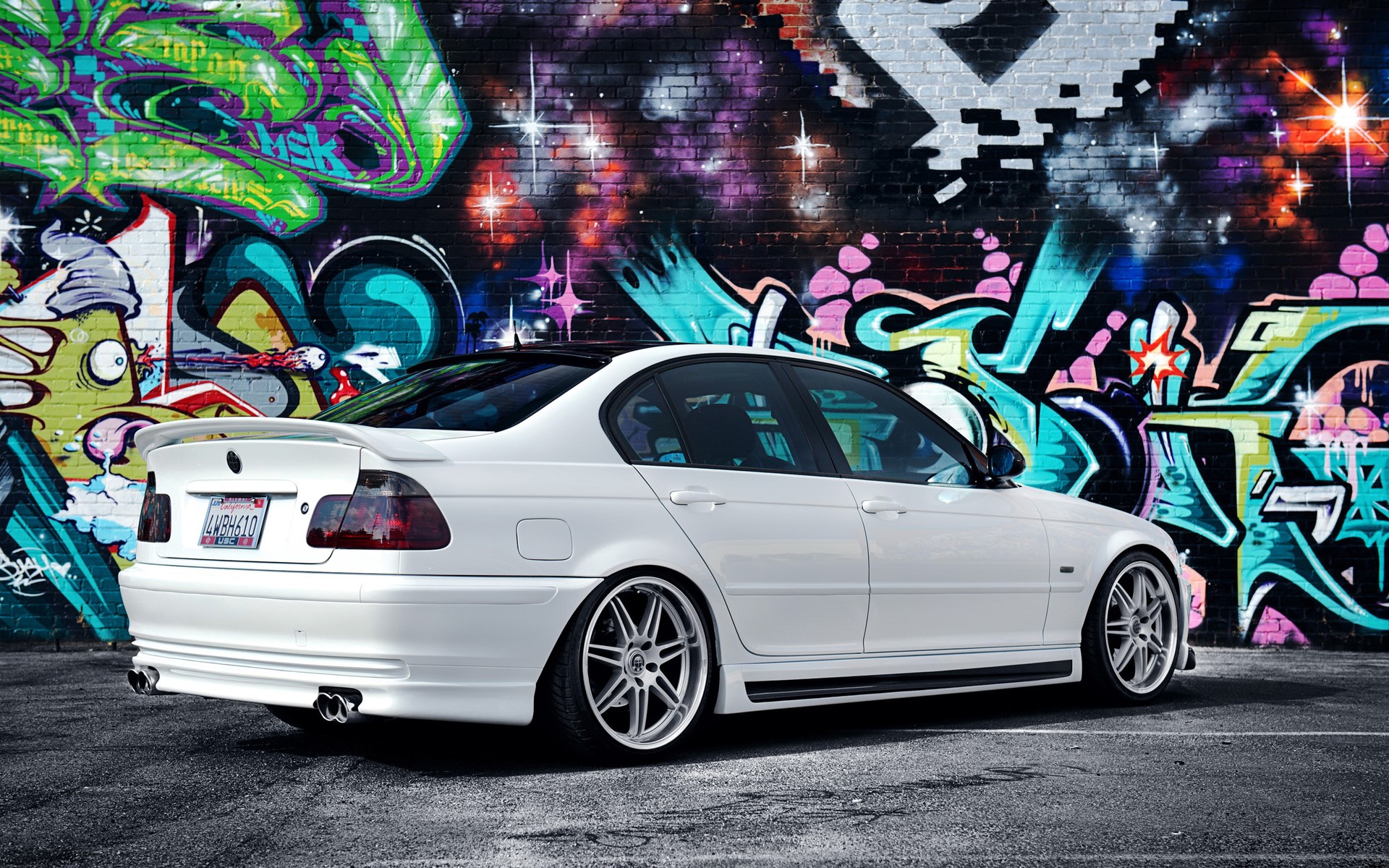 White BMW Sedan parked in front of graffiti wall HD Wallpaper