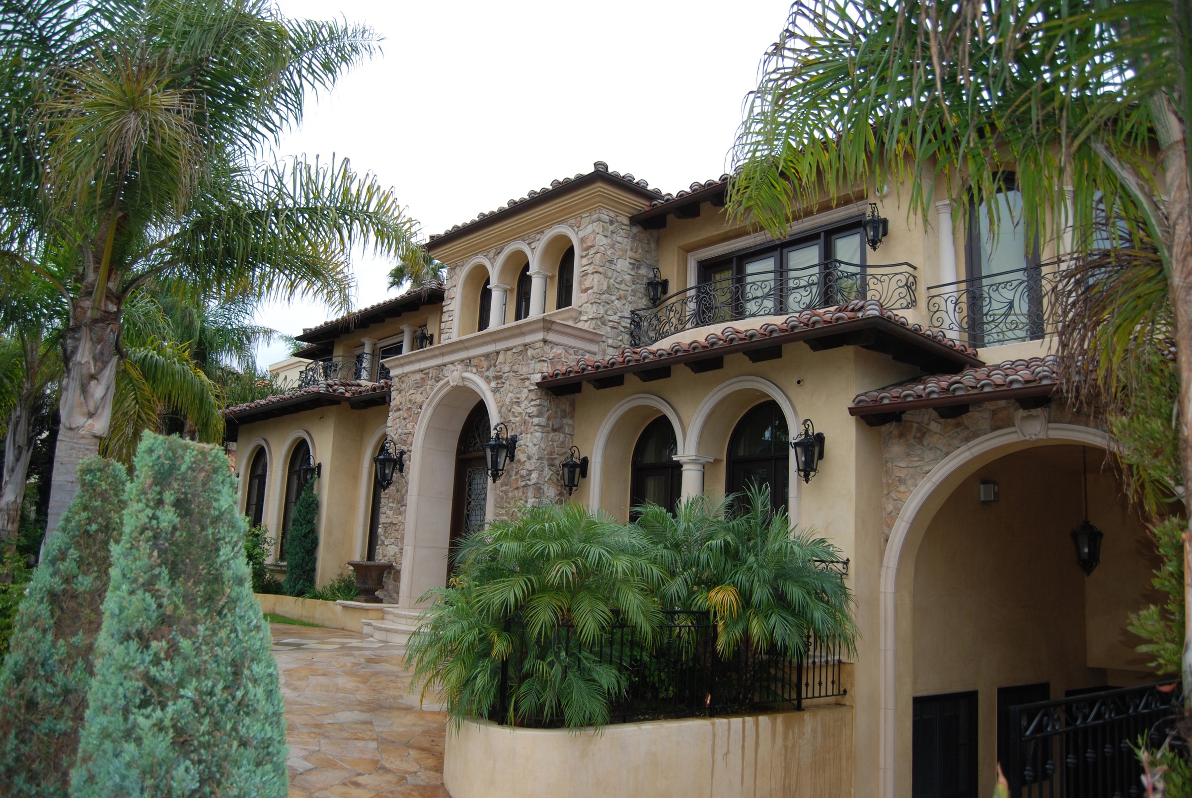Luxury Mediterranean mansion with palm trees and arched entryway HD Wallpaper