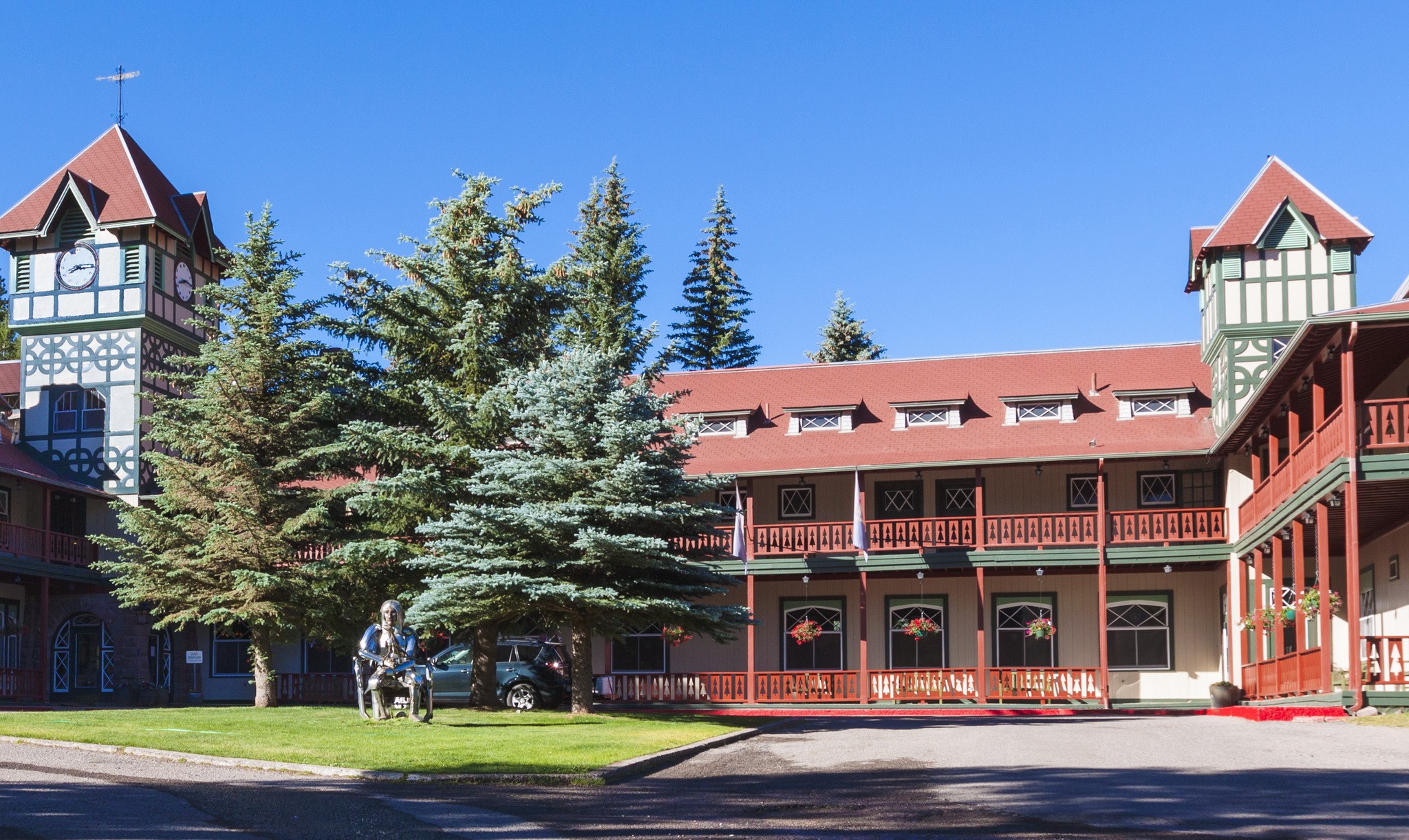 Hotel with clock tower and trees HD Wallpaper