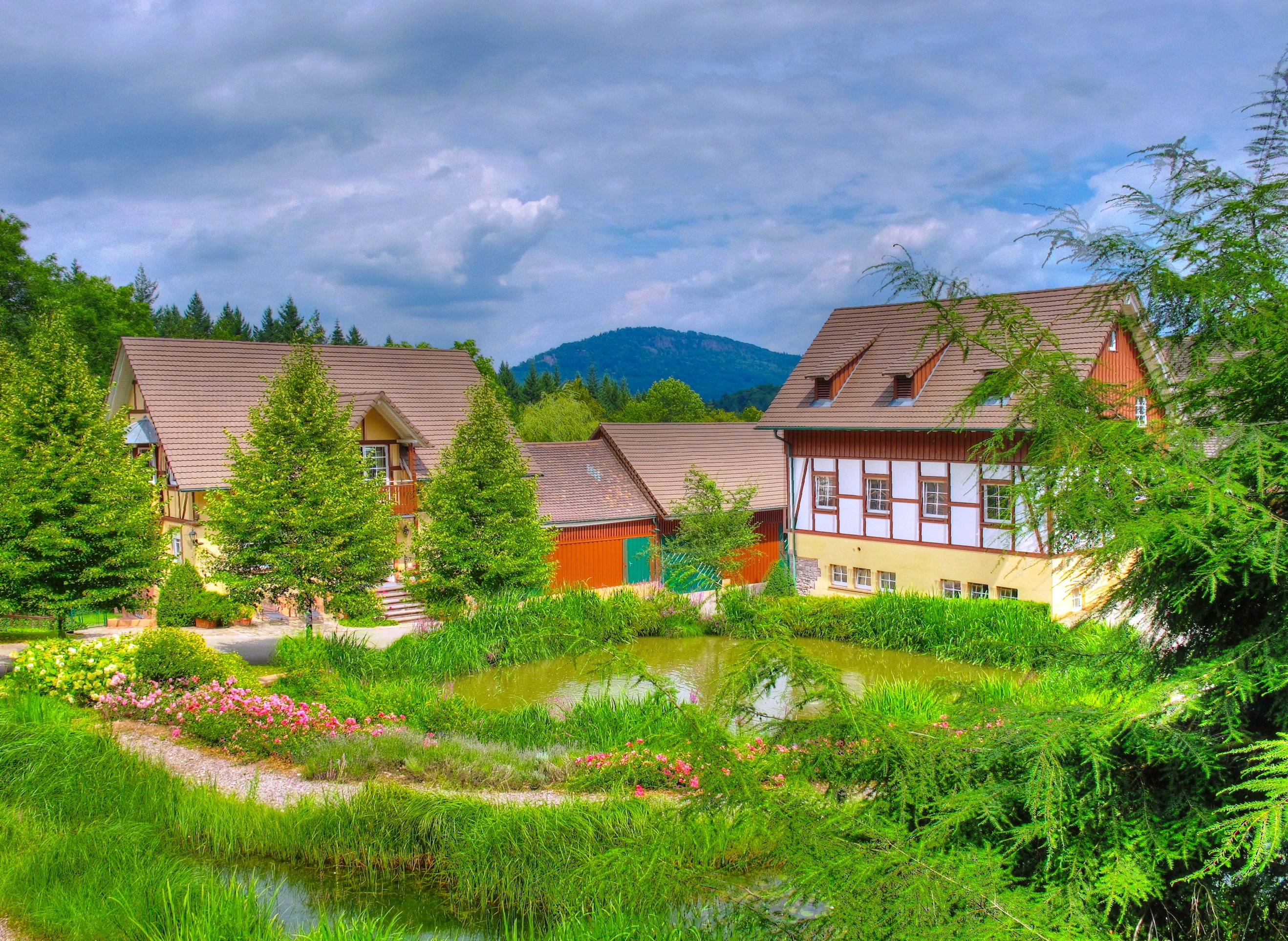 Half-timbered houses and pond in a German landscape HD Wallpaper