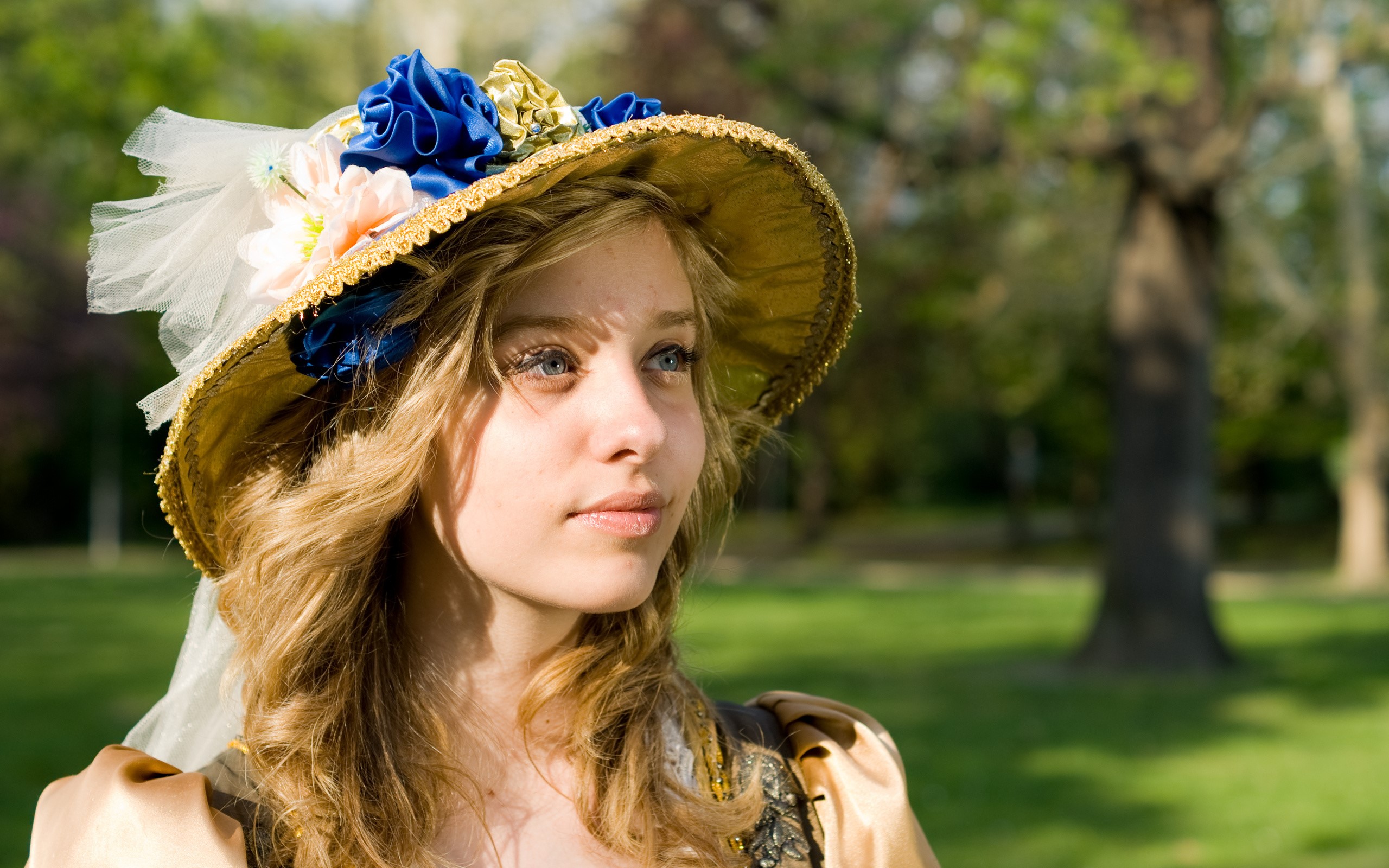 Woman in a decorative hat in a park HD Wallpaper
