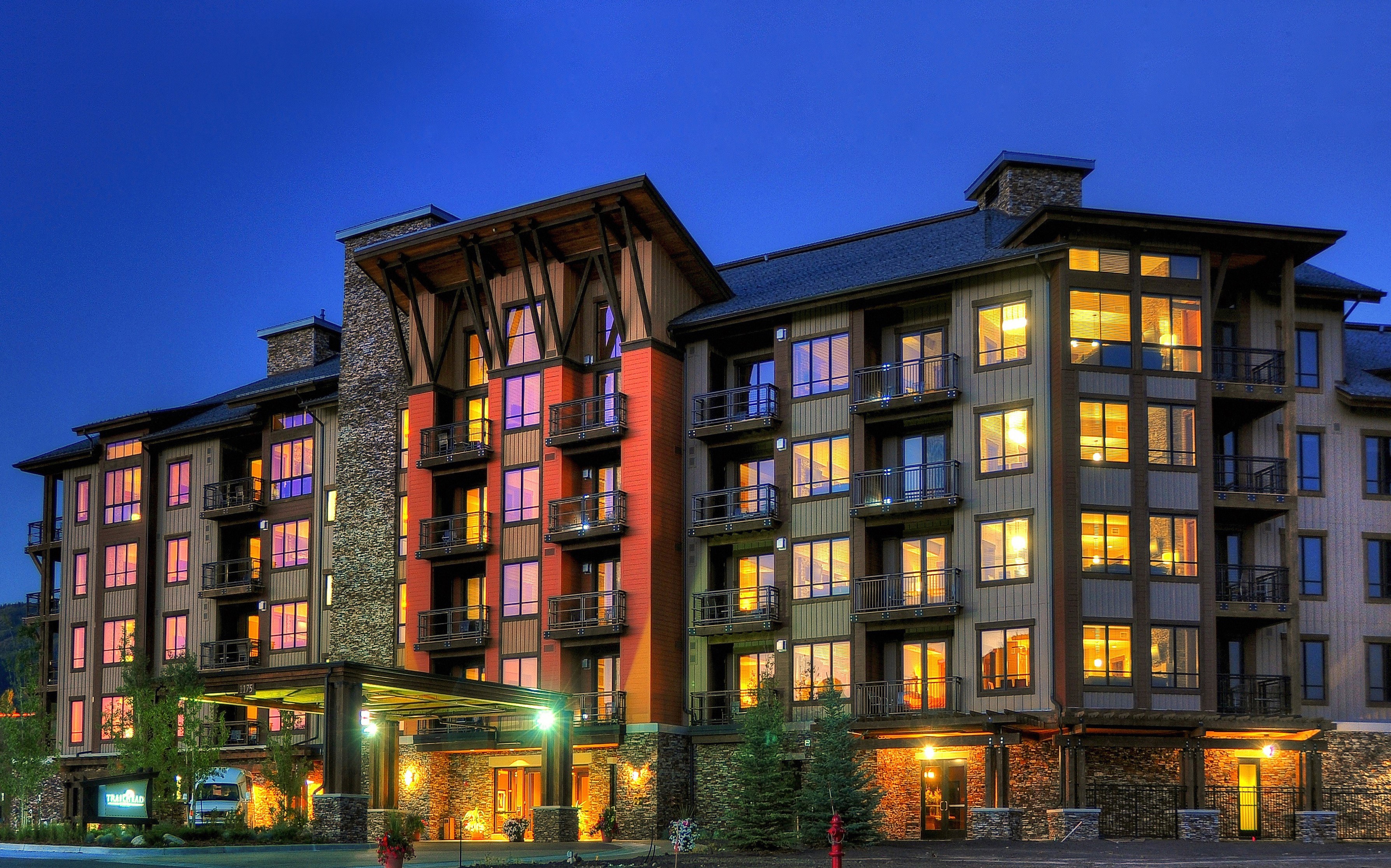 Luxury hotel building at night with illuminated windows HD Wallpaper